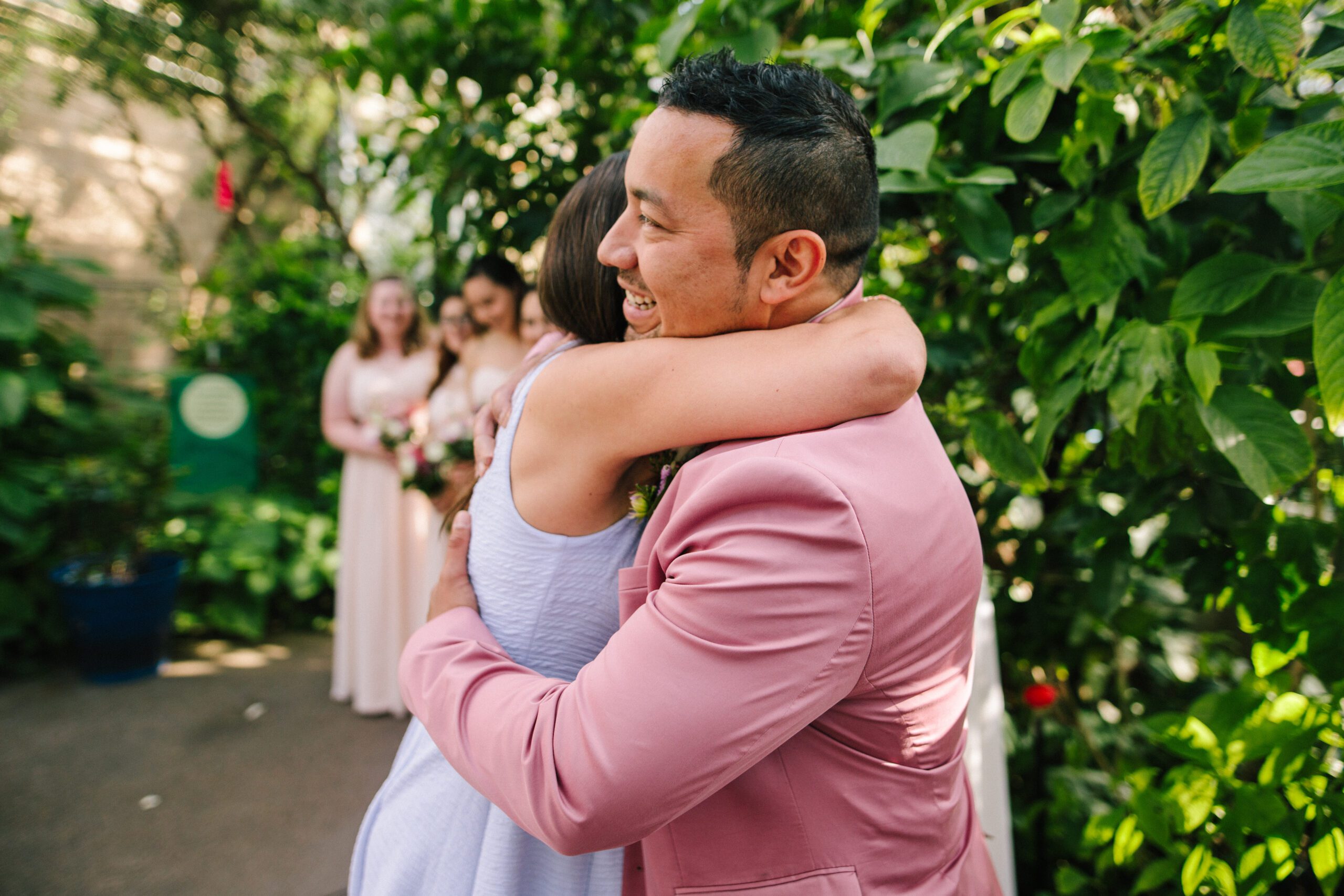The groom hugs he family during the ceremony at his Butterfly Pavilion wedding. 