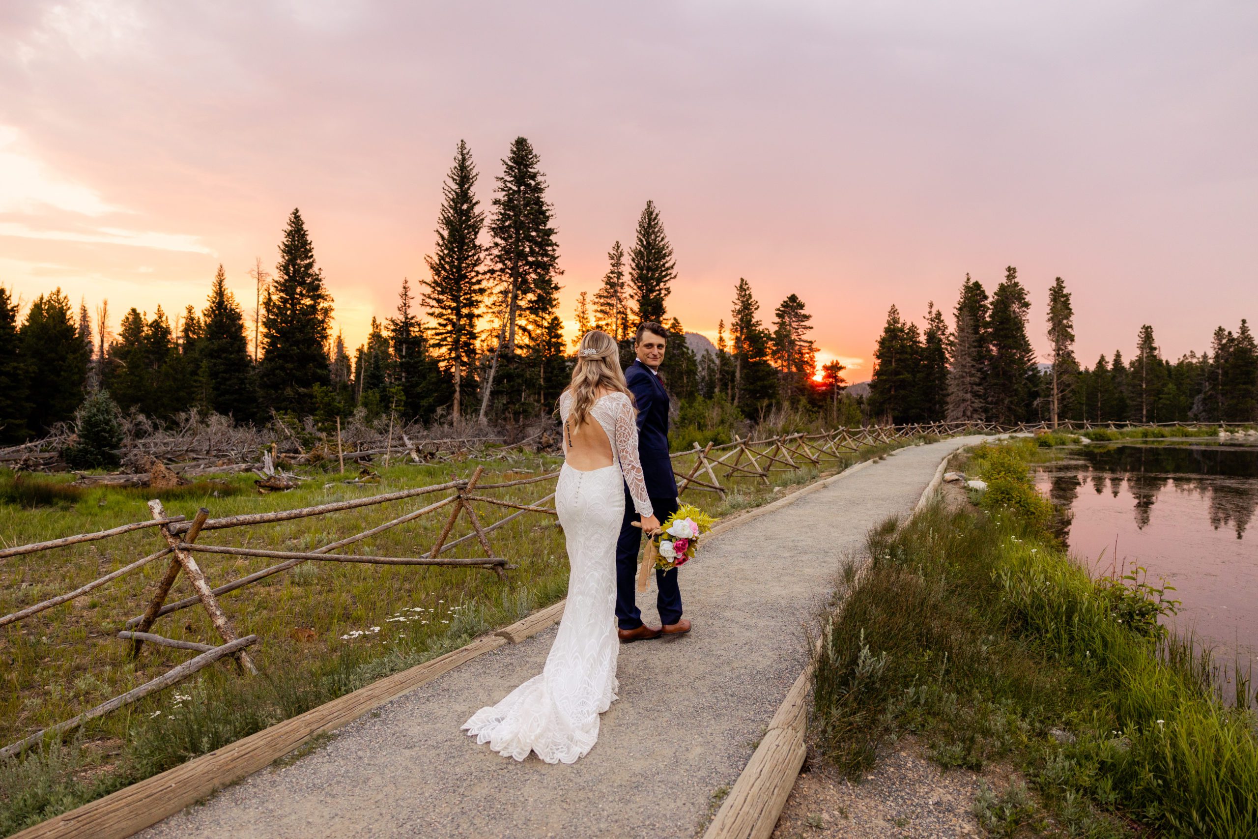 Bride and groom go for a sunrise hike at Sprague Lake in Rocky Mountain National Park Colorado