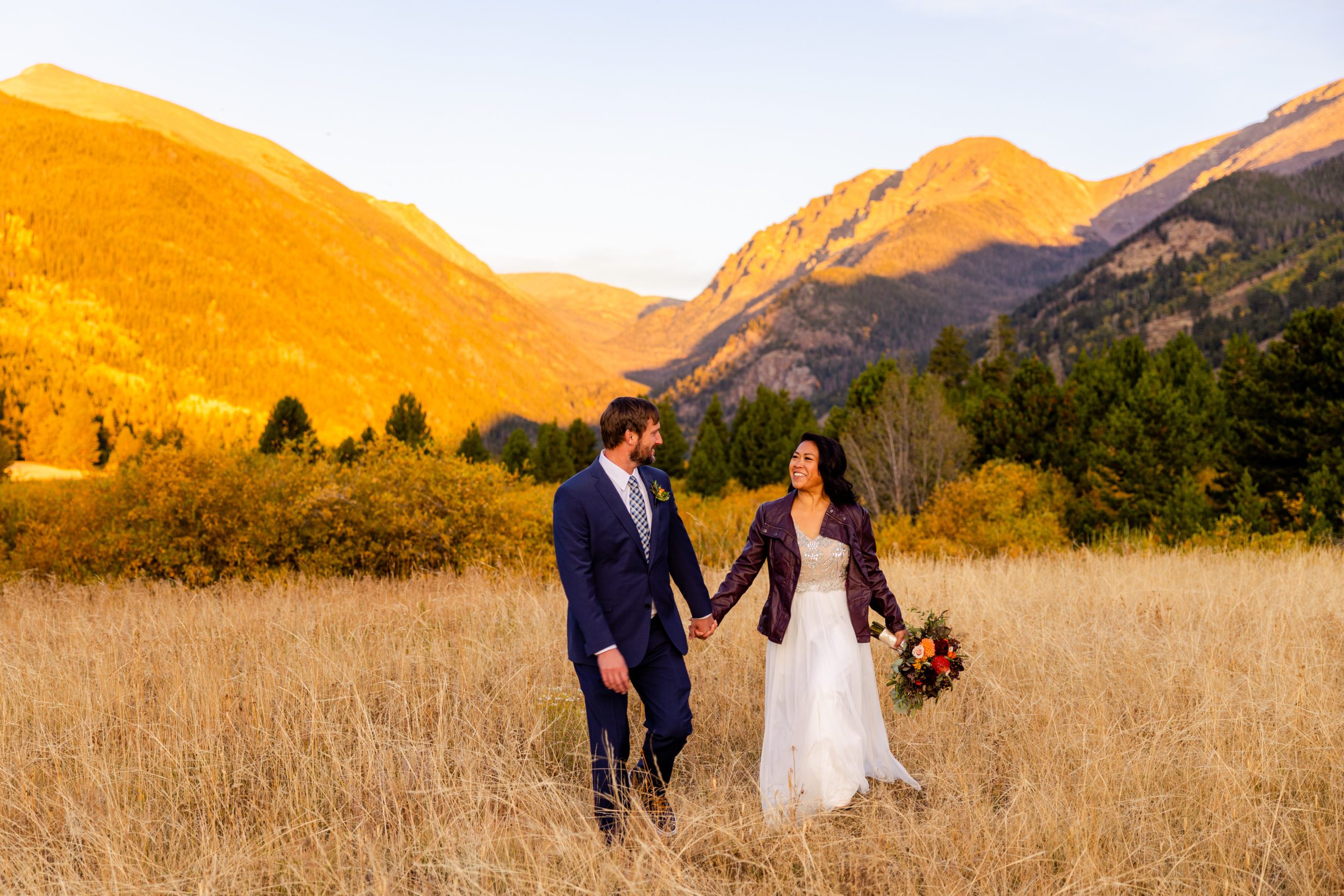 Bride and groom walking in Rocky Mountain National Park with the Alluvial Fan Mountain Range backdrop
