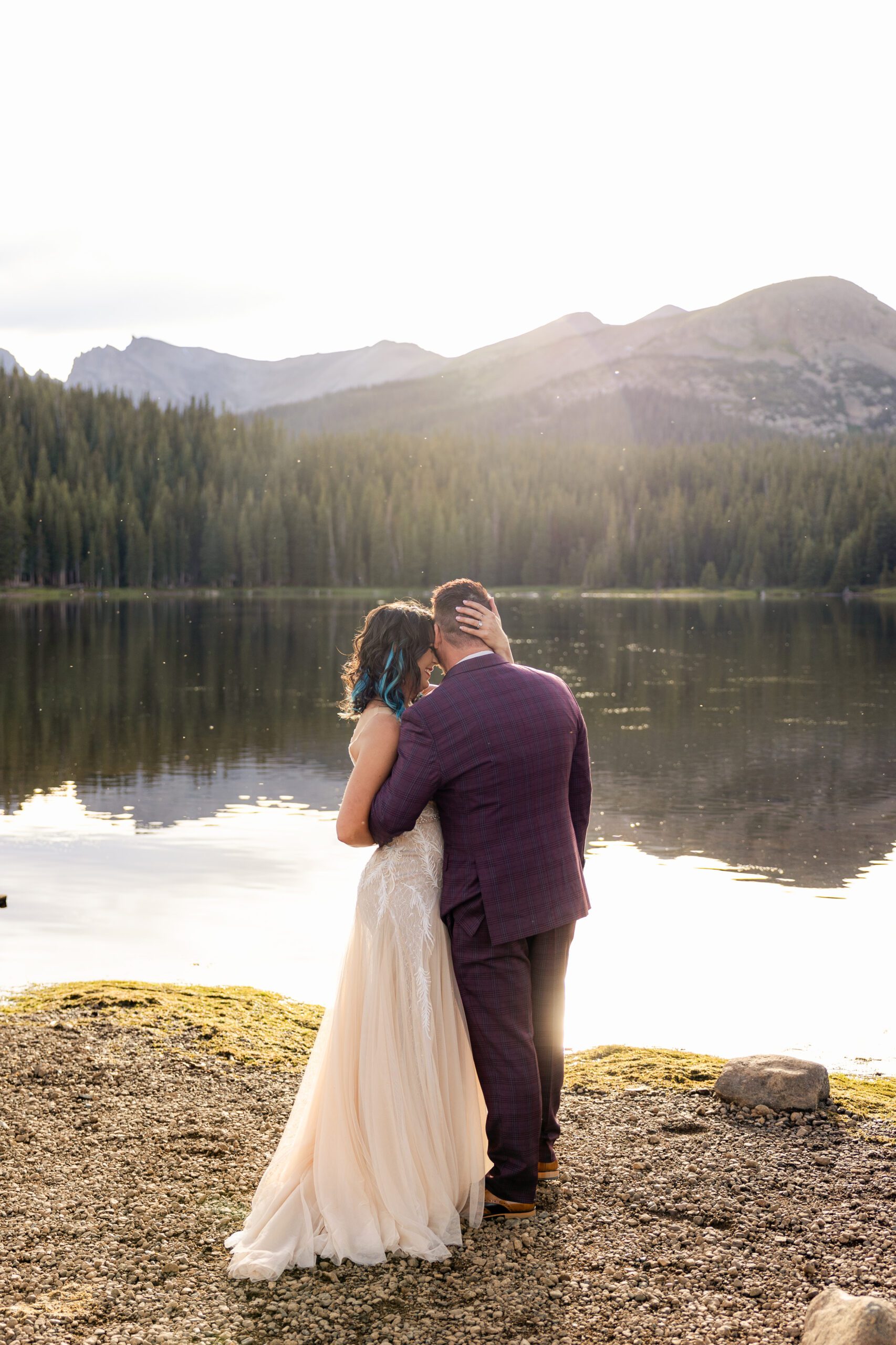 bride and groom cuddled up together near the lake at their Brainard Lake Elopement.