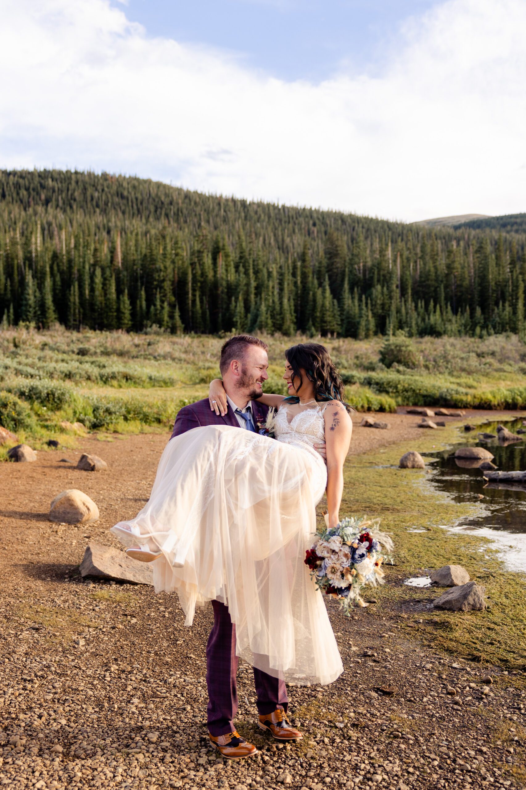 The groom carrying his bride near the lake after their Brainard Lake Elopement.