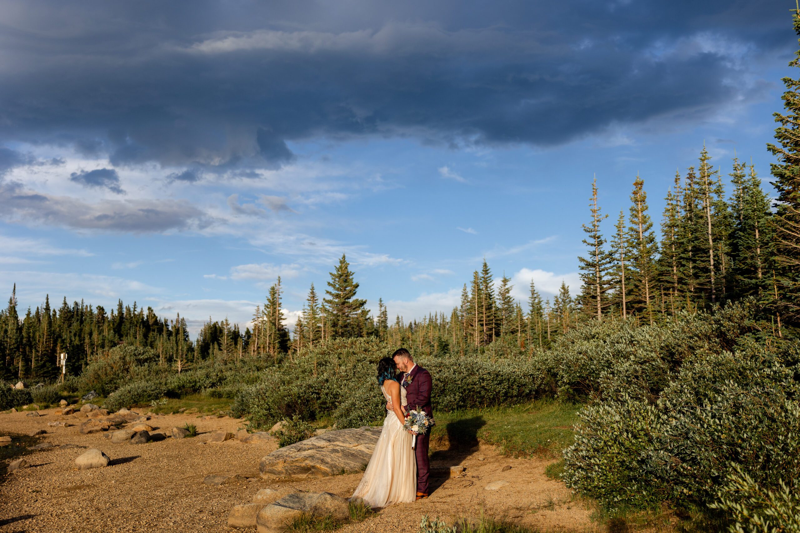 The bride and groom kissing in the meadow after their Brainard Lake Elopement. 