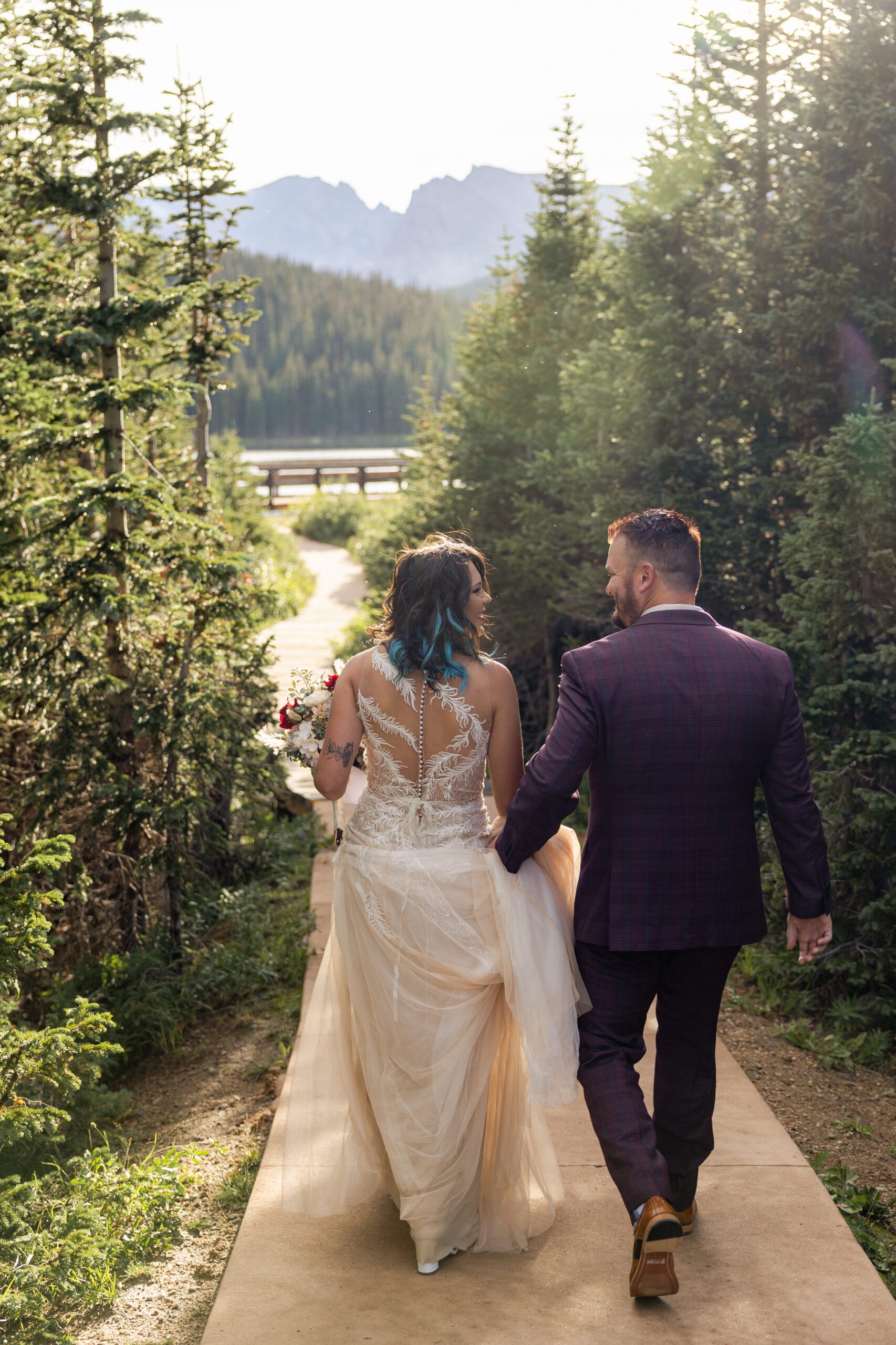 Groom and bride walking to their ceremony smiling at each other before their Brainard Lake Elopement/