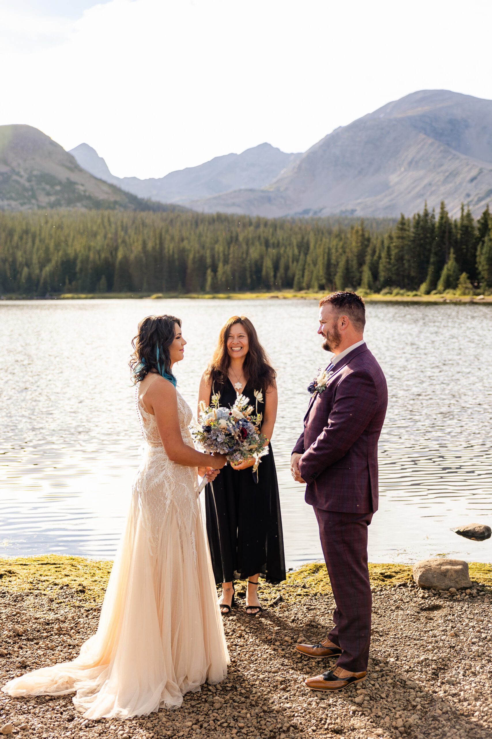 The beginning of their Brainard Lake Elopement near the lake. The Bride and groom smiling at eachother. 