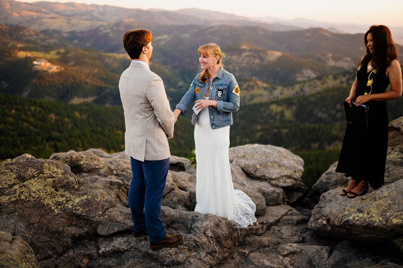 bride sweetly reaches for grooms hand, atop Flagstaff at their Lost Gulch Overlook elopement at sunrise