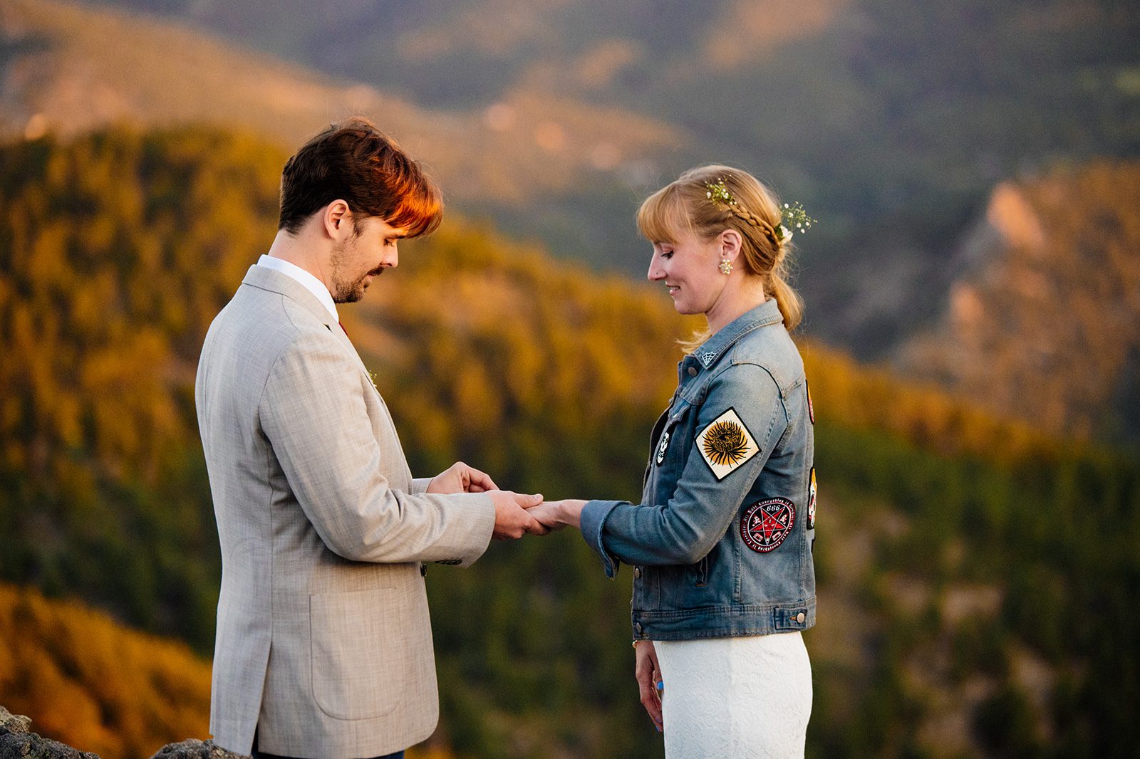 groom puts rings on his brides finger at sunrise during their Lost Gulch Overlook elopement