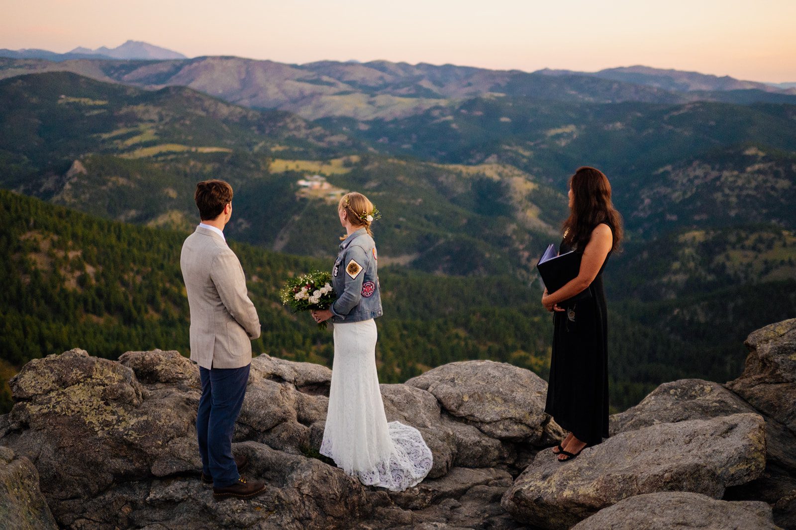 bride and groom look over the Colorado rockies at sunset on their elopement day at Lost Gulch Overlook. 
