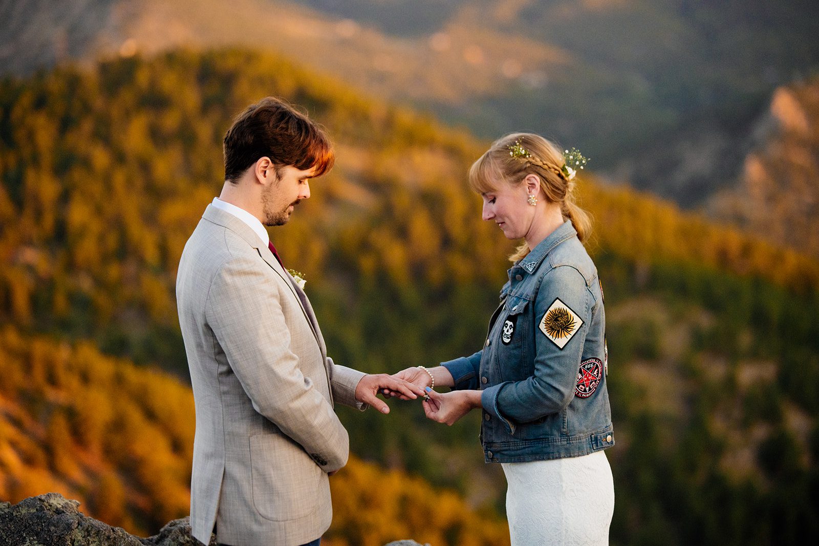 bride puts ring on grooms hand during sunrise ceremony at Lost Gulch Overlook in boulder, colorado