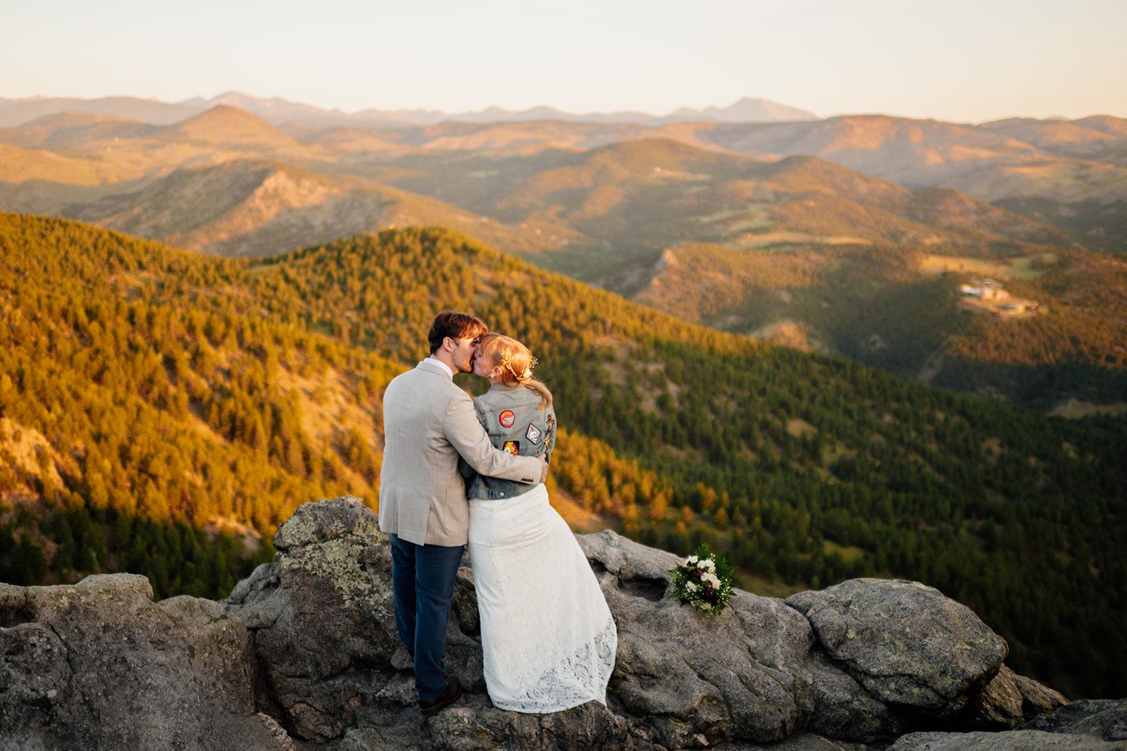 bride and groom facing the rocky mountains at sunrise during their Lost Gulch Overlook elopment ceremony 