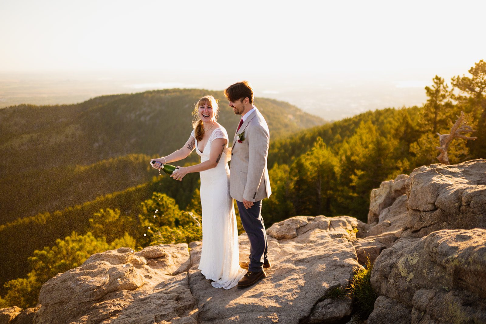 bride and groom laughing at Lost Gulch Overlook after champagne celebration. 