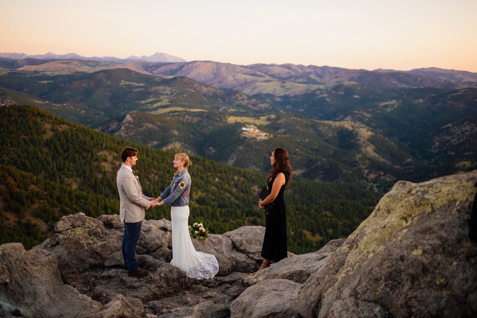 officiate stands by during sunrise ceremony at Lost Gulch Overlook with bride and groom