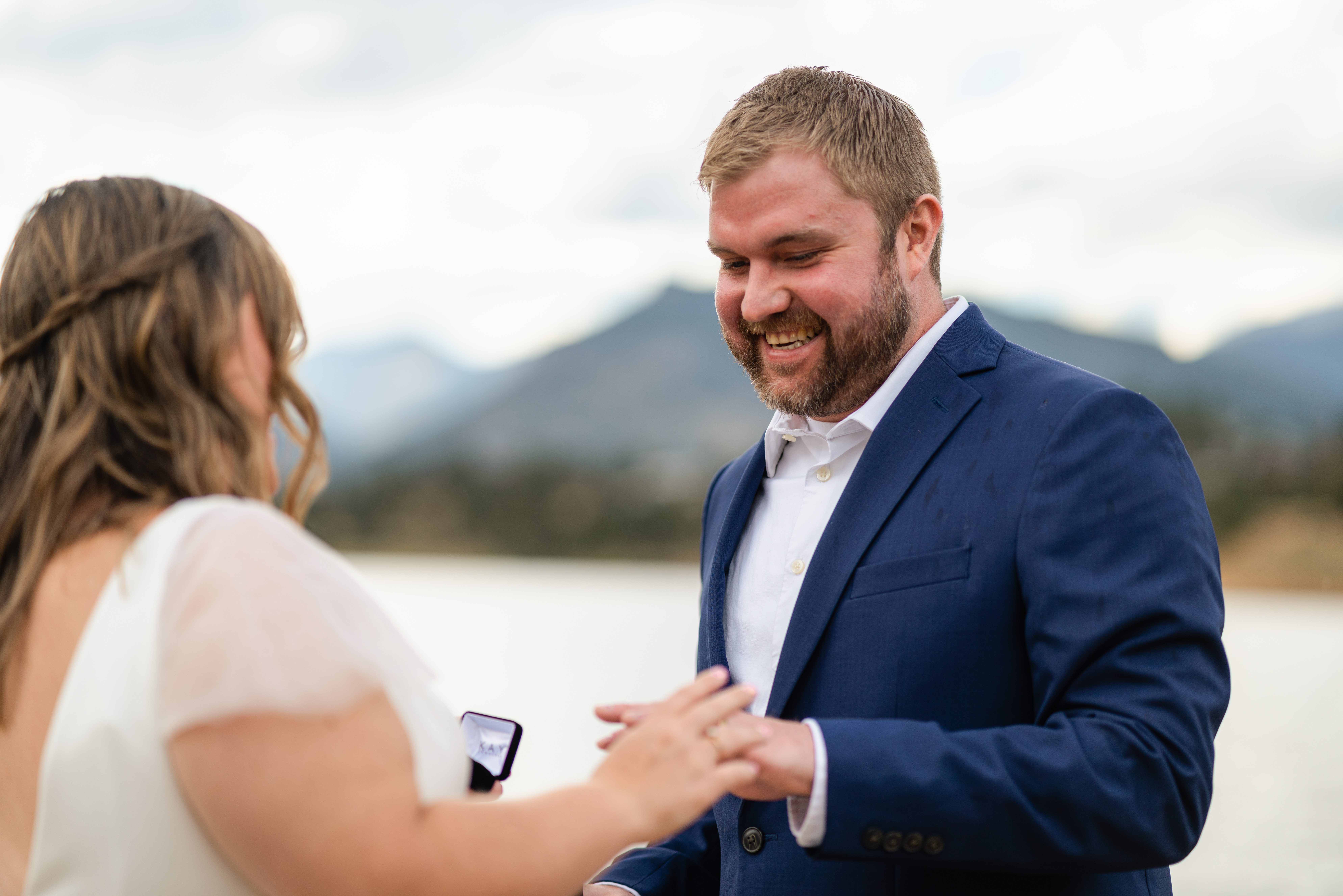 the bride puts ring on grooms hand at their Bear Lake elopement. 