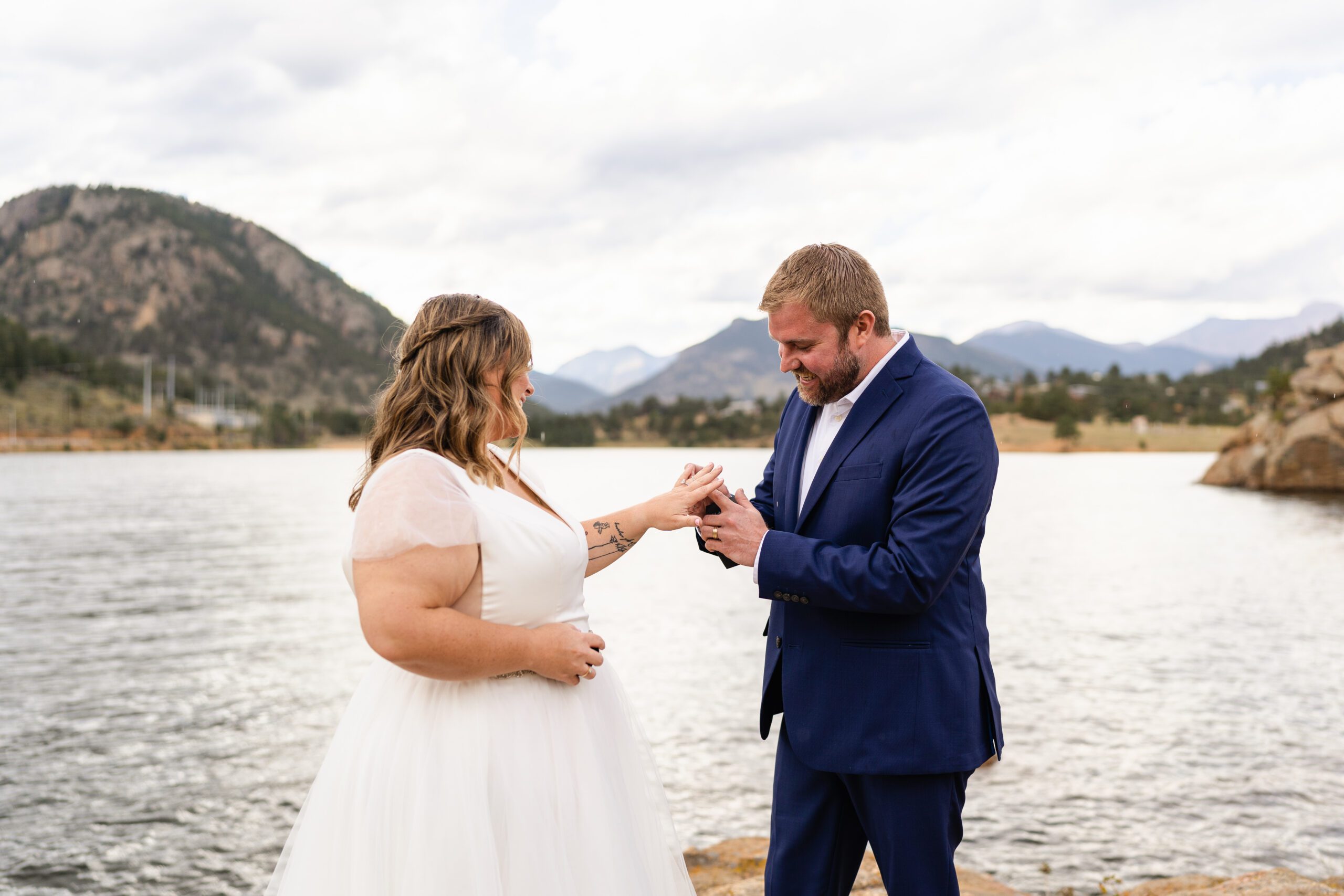groom puts ring on brides hand at their Bear Lake elopement. 