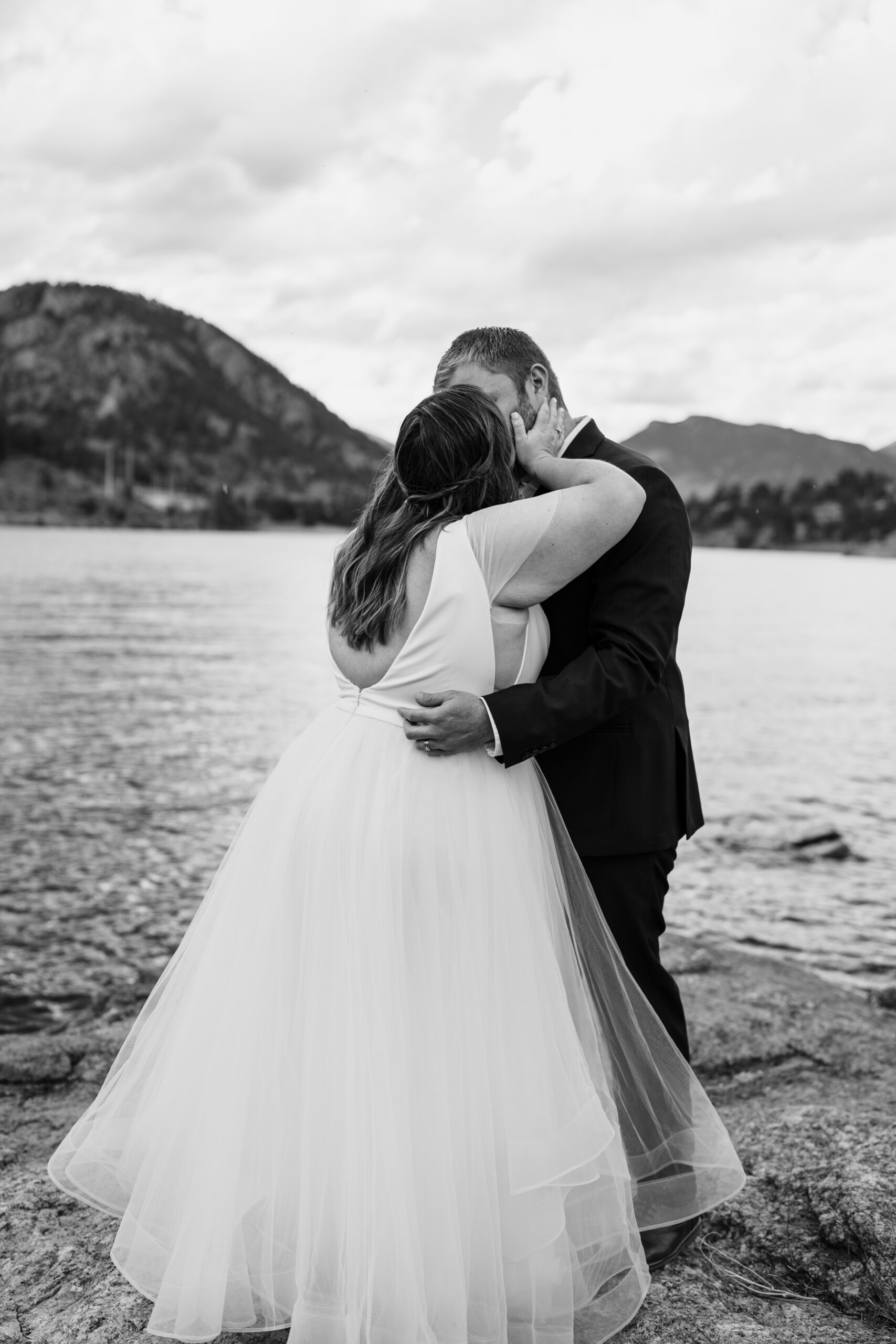 a black and white photo of the bride and groom kissing near the lake after their ceremony at their their Bear Lake elopement. 