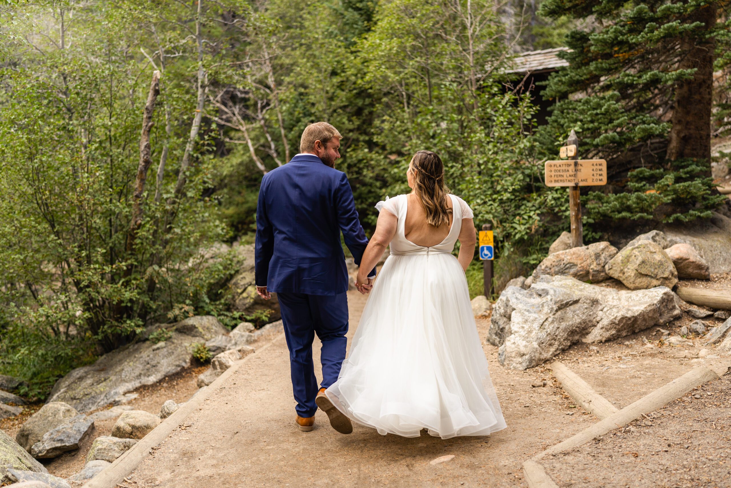 the bride and groom holding hands and walking away during their Bear Lake elopement. 