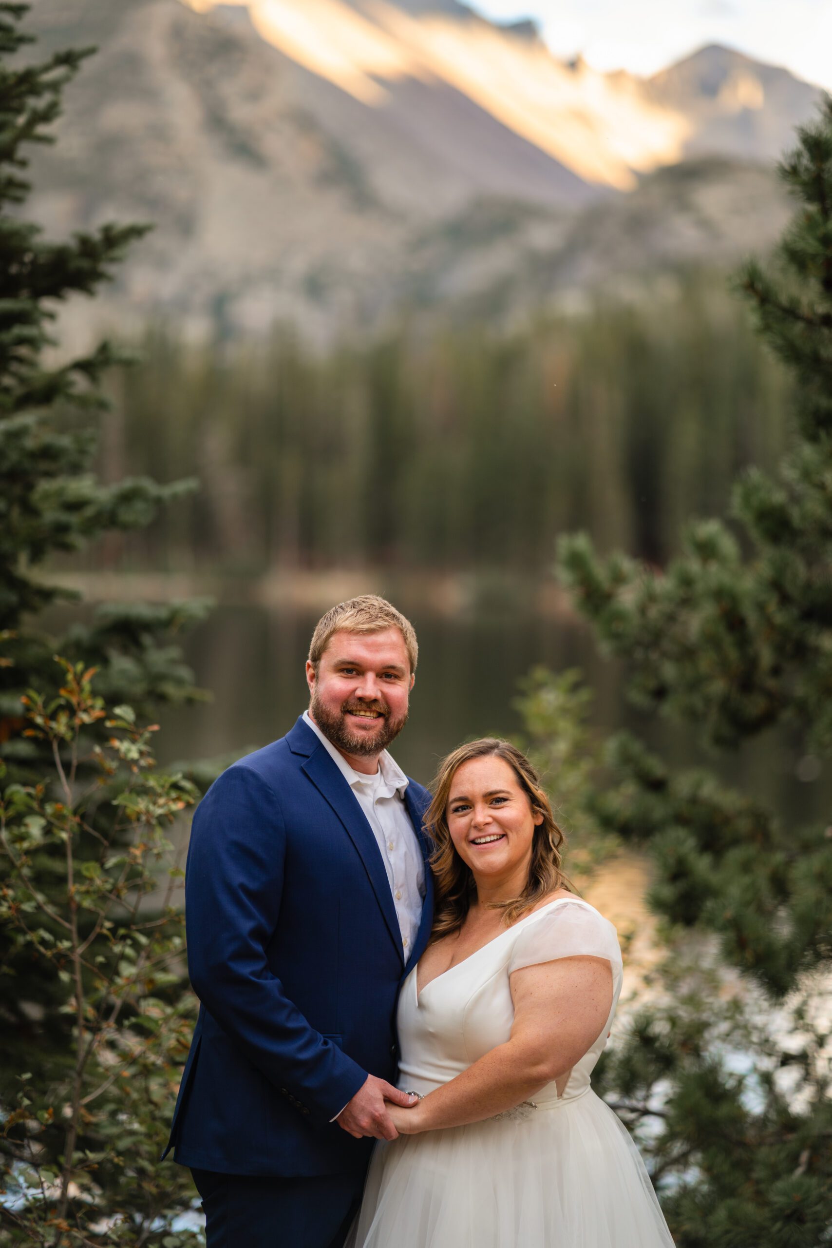 the bride and groom looking at the camera, a gorgeous mountain behind them at their Bear Lake elopement. 
