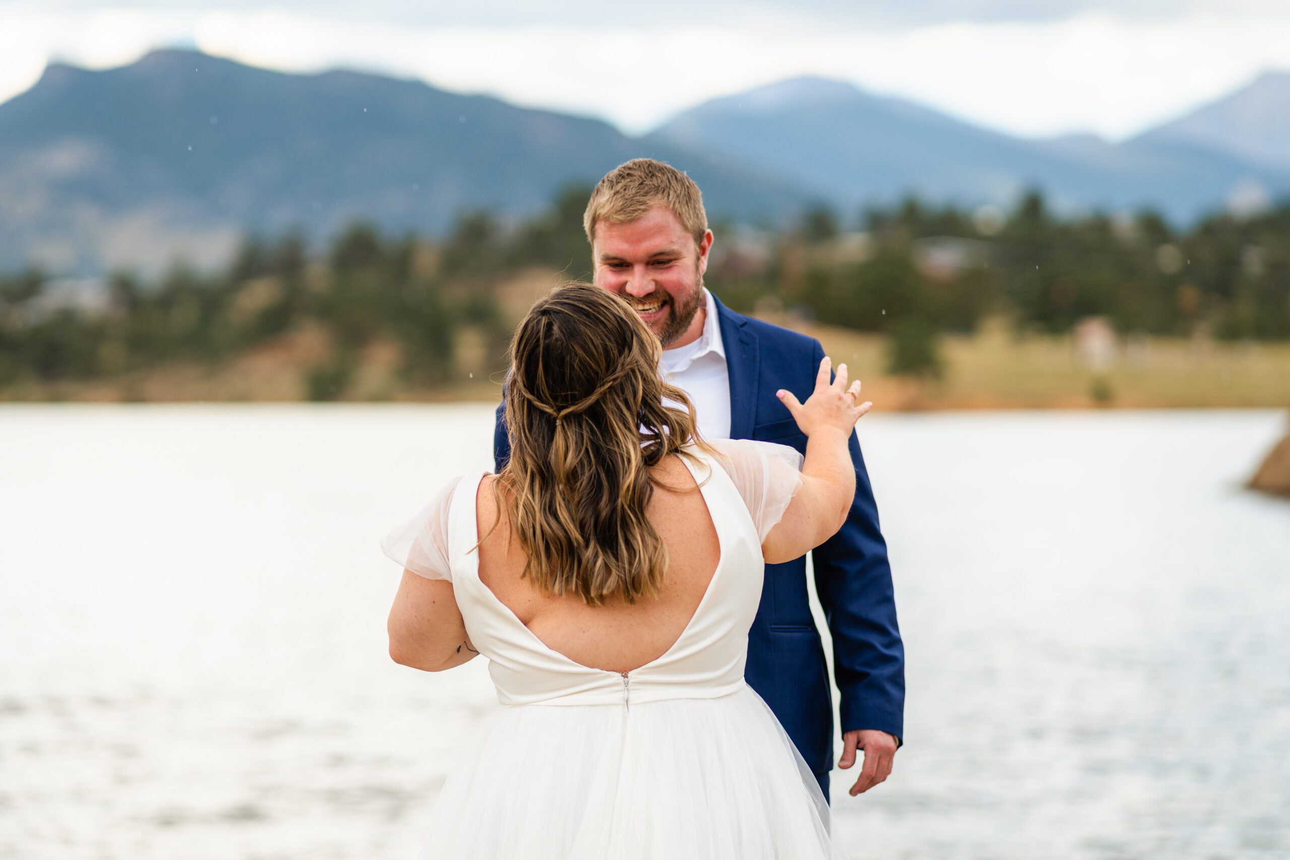 groom and bride smiling at each other near the lake at their Bear Lake elopement. 