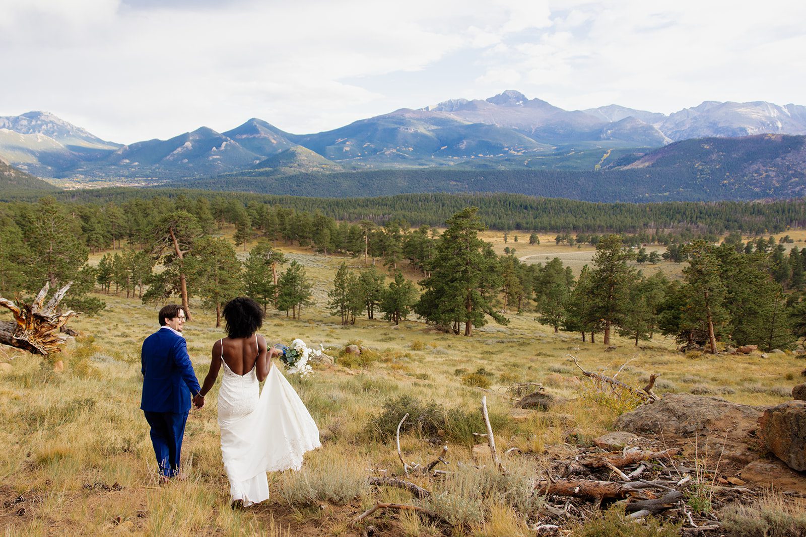bride and groom walking in rocky mountain national park. 