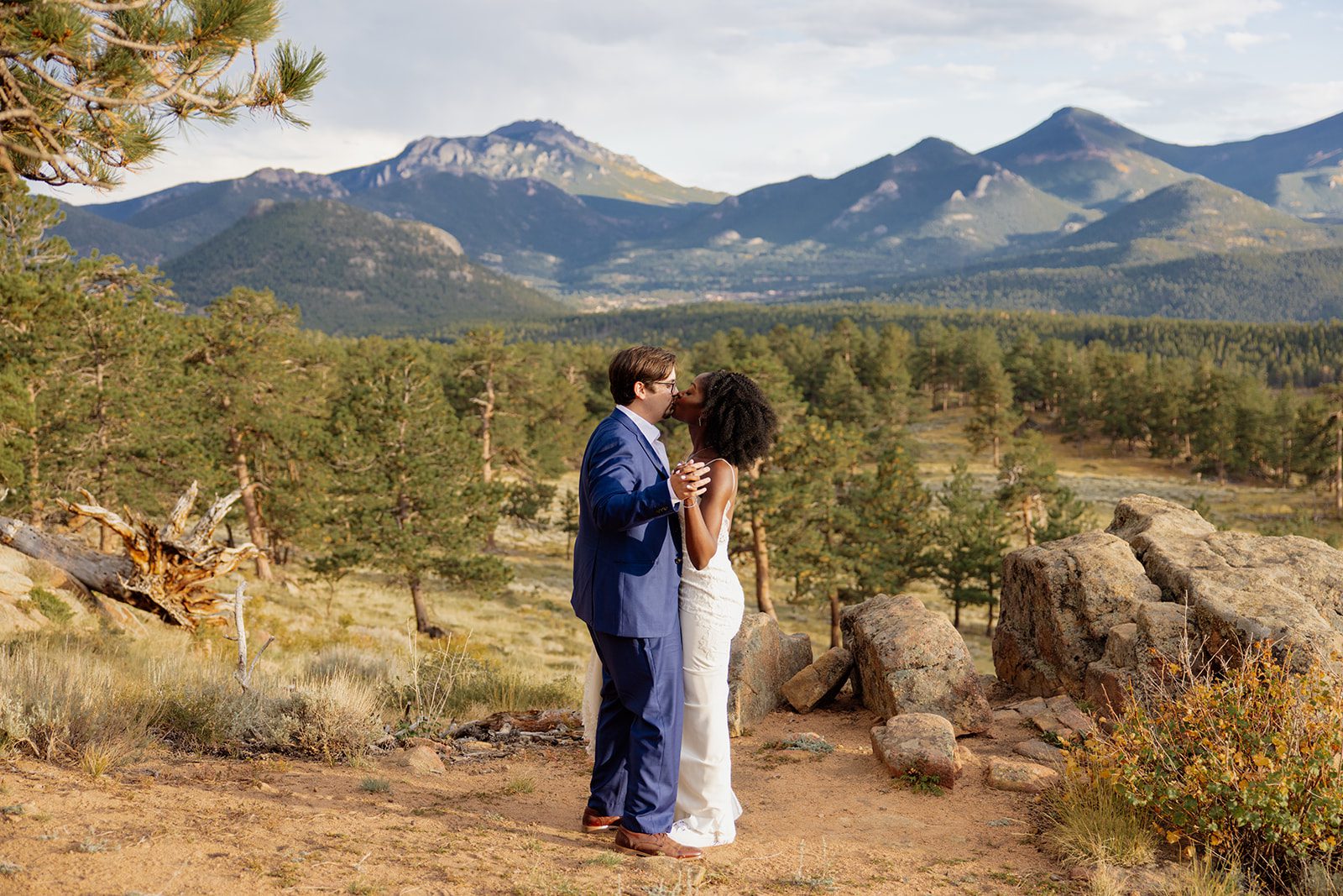 bride and groom kissing at sunset during their first dance at rocky mountain national park. 