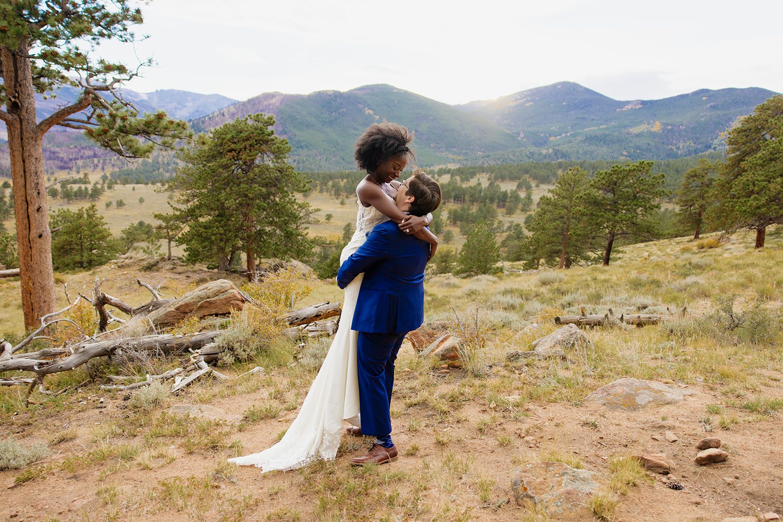 groom holding his new bride at Rocky Mountain National Park after their intimate Knoll Willows Elopement ceremony. 
