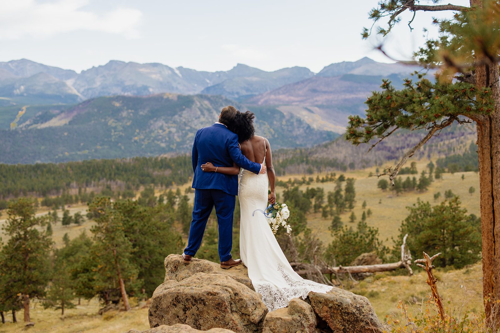 bride and groom looking at the rockies in Rocky Mountain National Park after their Knoll Willows Elopement ceremony. 