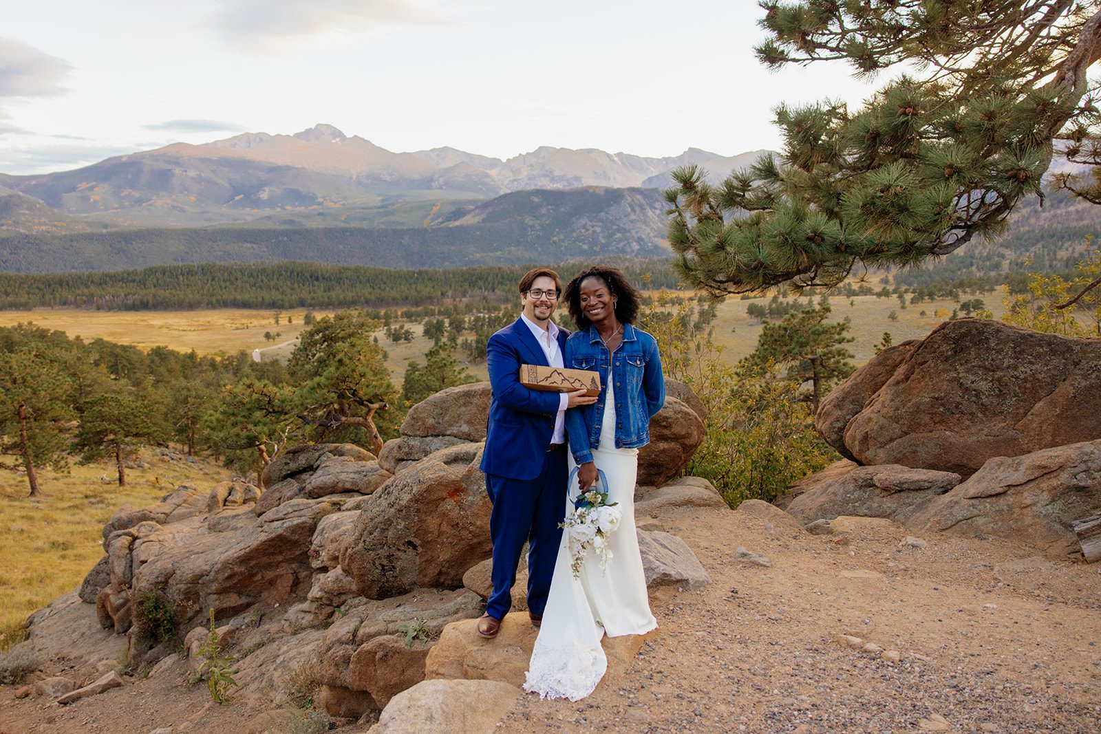 Bride and groom holding wine box in Rocky Mountain National Park from their Knoll Willows Elopement ceremony.