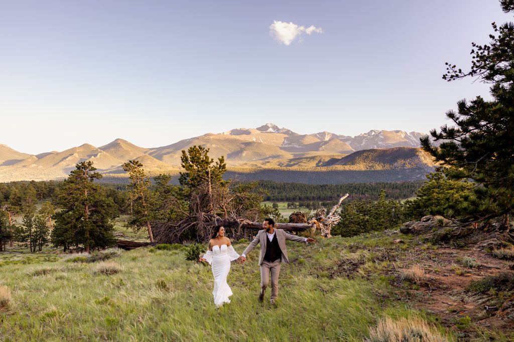 bride and groom running through a beautiful meadow on their elopement day 