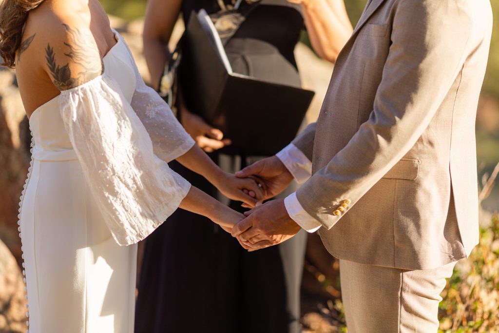 bride and groom holding hands during ceremony 