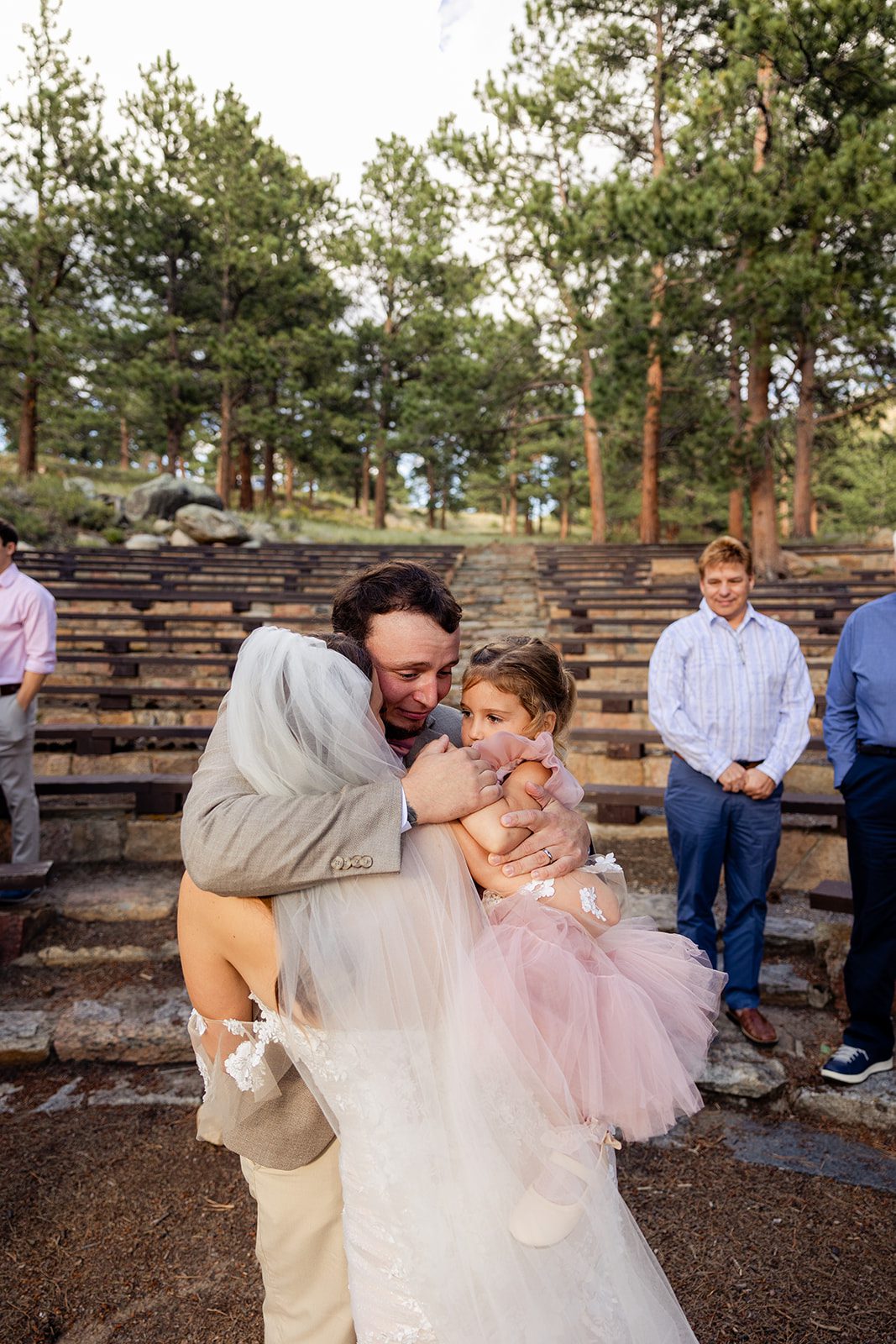 The bride and groom embrace their young daughter after their ceremony. 