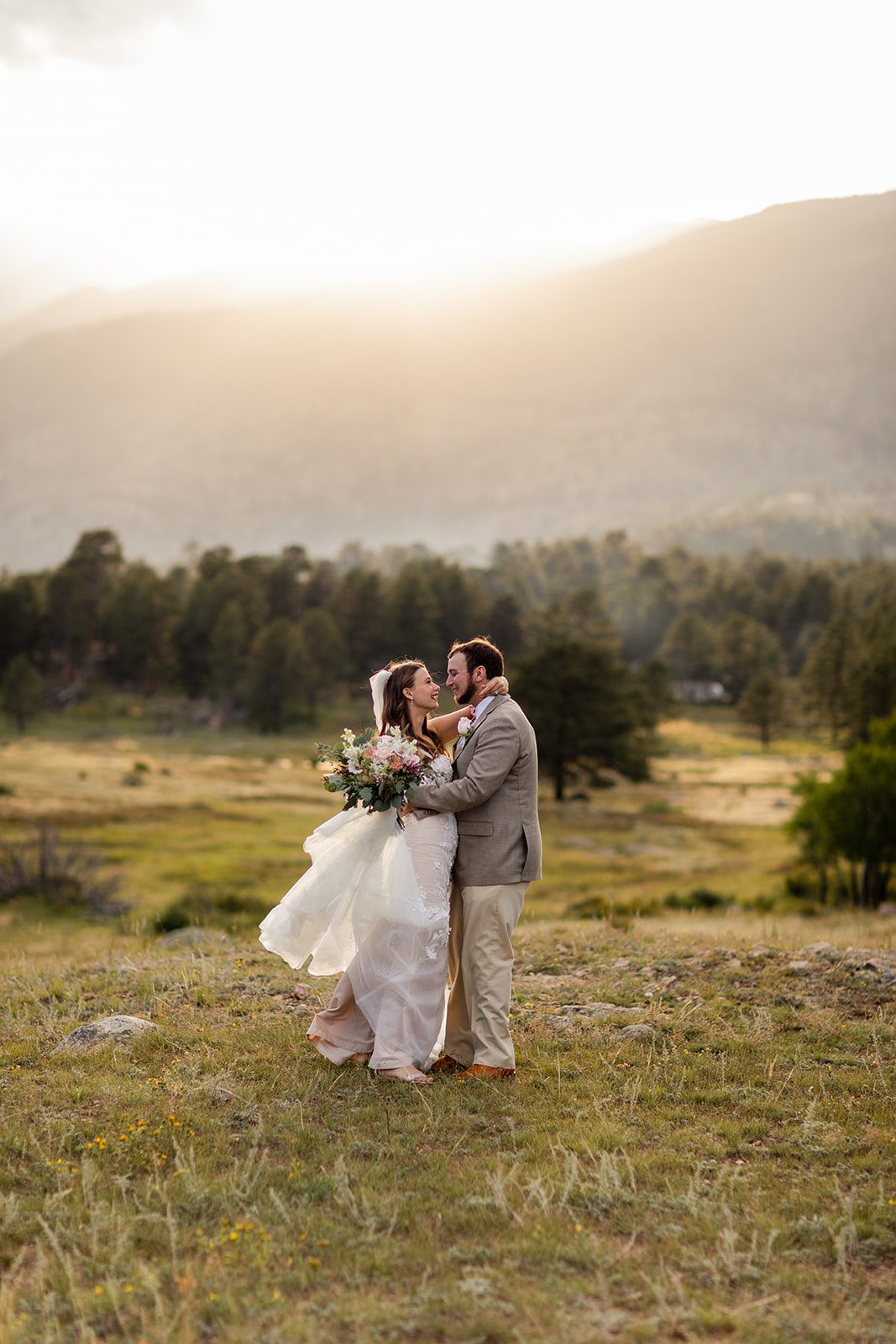 The bride and groom look at each other during sunset in the valley. 