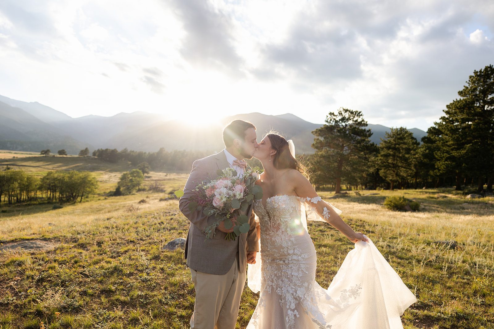 The bride and groom kiss as the sunlight dances on their face. 