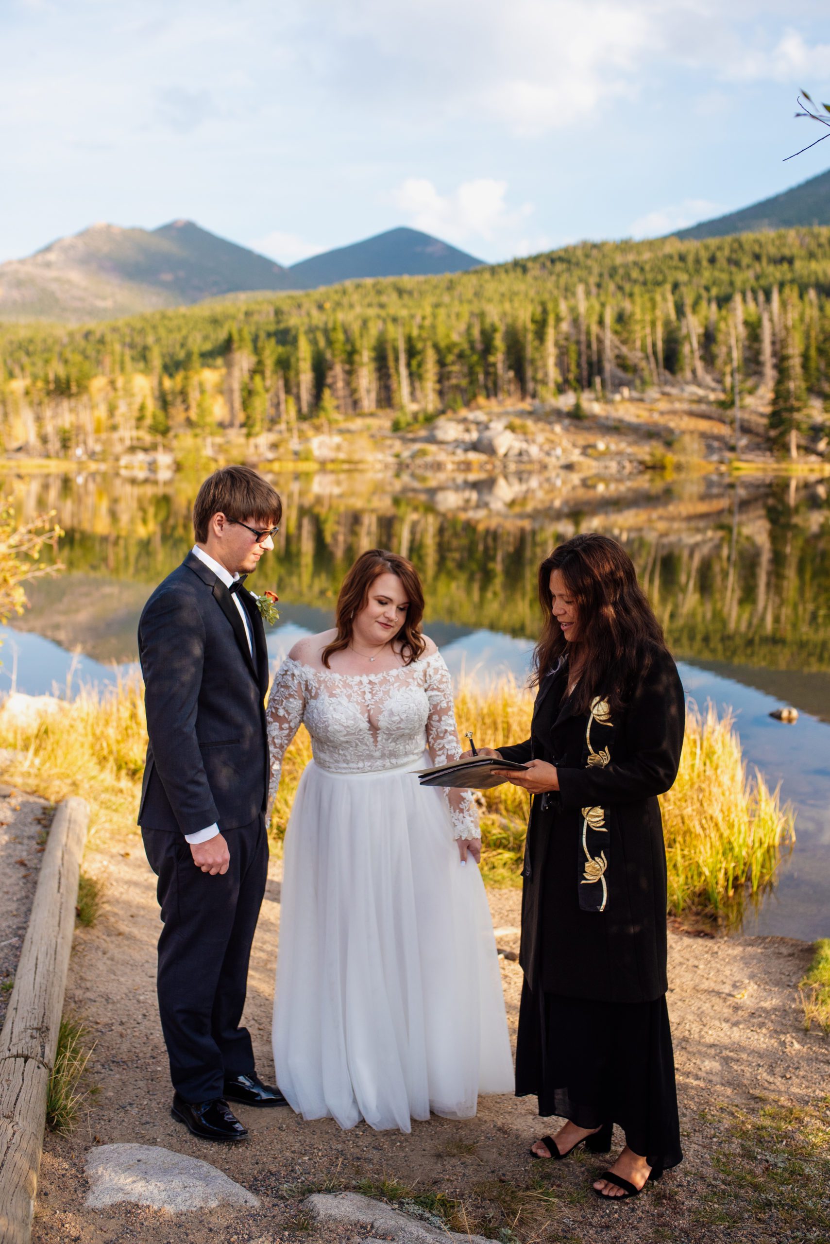 Officiant shows bride and groom marriage license at Sprague Lake - RMNP