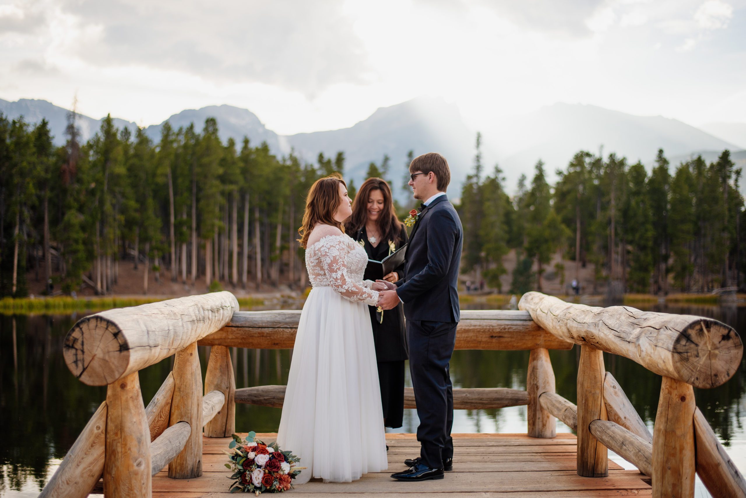 Bride and Groom holding hands during elopement ceremony at Sprague Lake - RMNP
