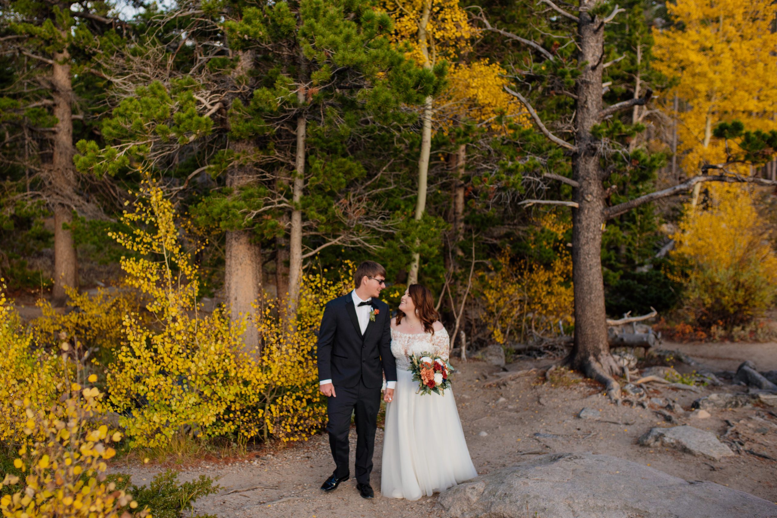 Bride and groom walking around Sprague Lake 