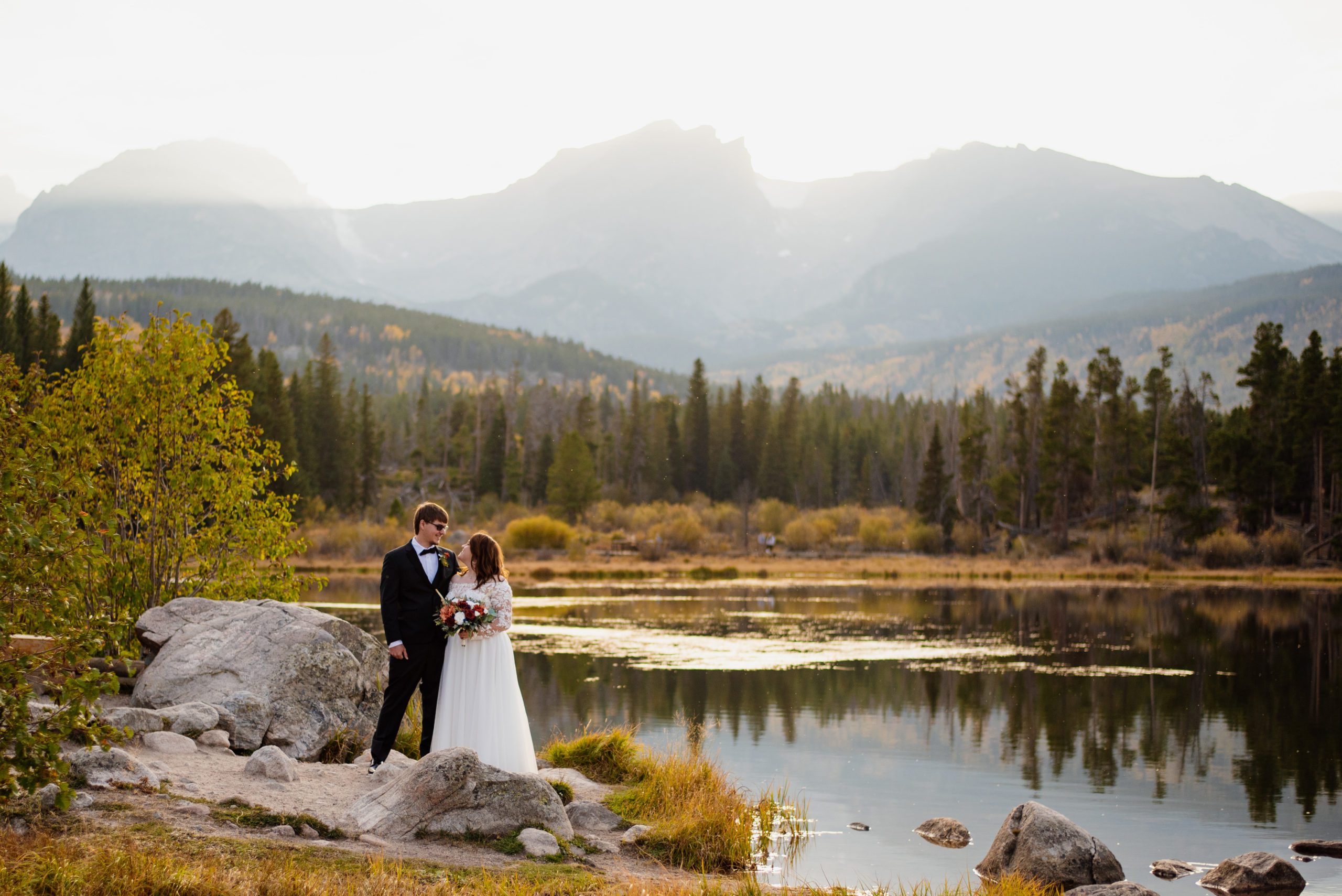Bride and groom standing together at Sprague Lake - RMNP