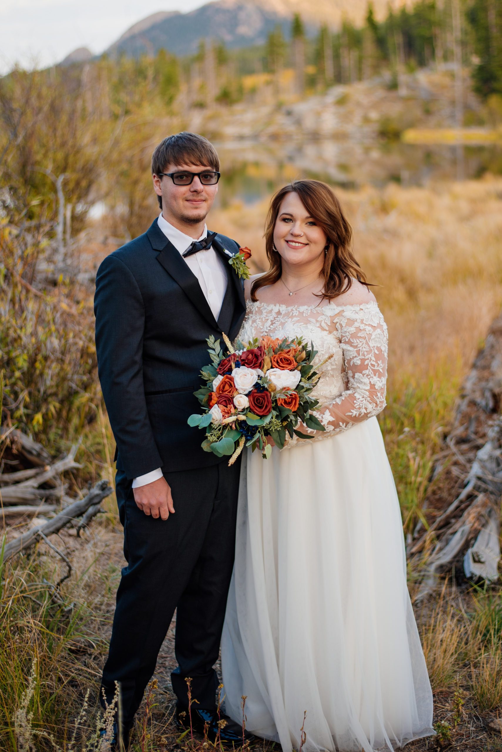 Bride and groom smiling at the camera at Sprague Lake - RMNP
