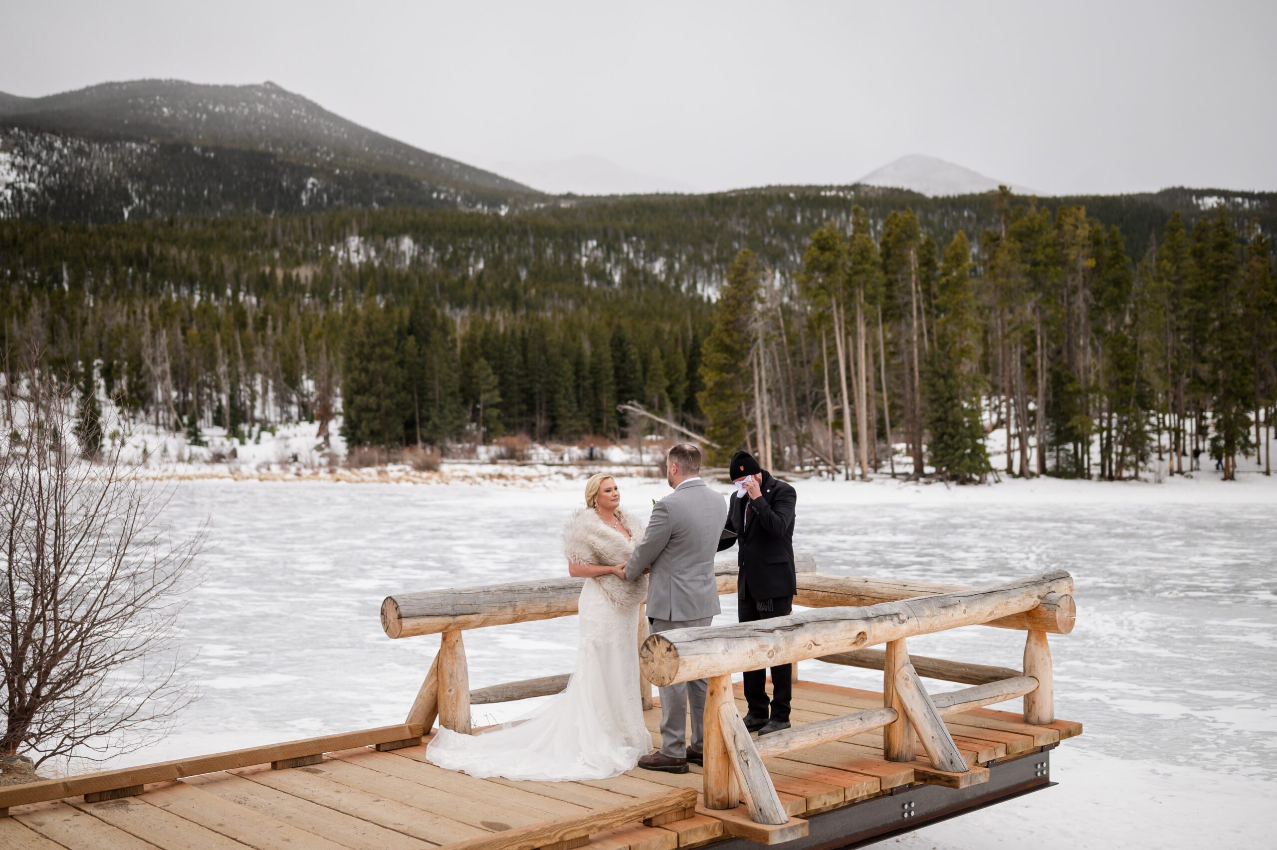 the officiant wipes his tears during his sister's Winter Elopement at Sprague Lake. 