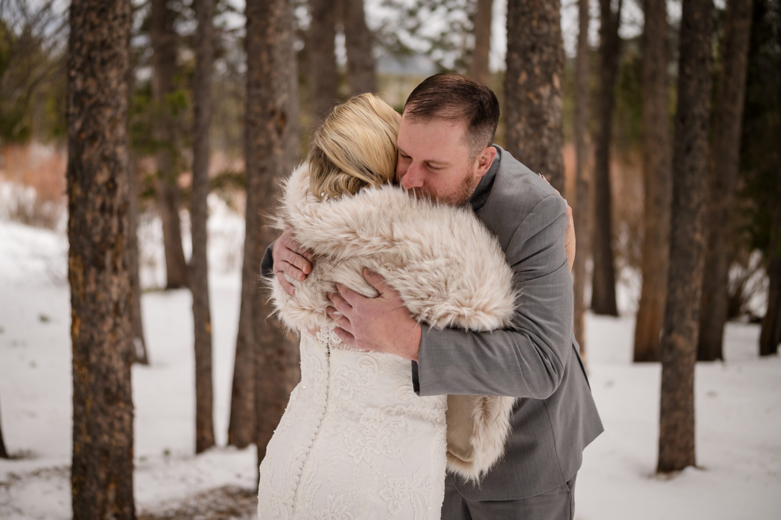 Groom hugs his bride after their first look at their Winter Elopement at Sprague Lake. 