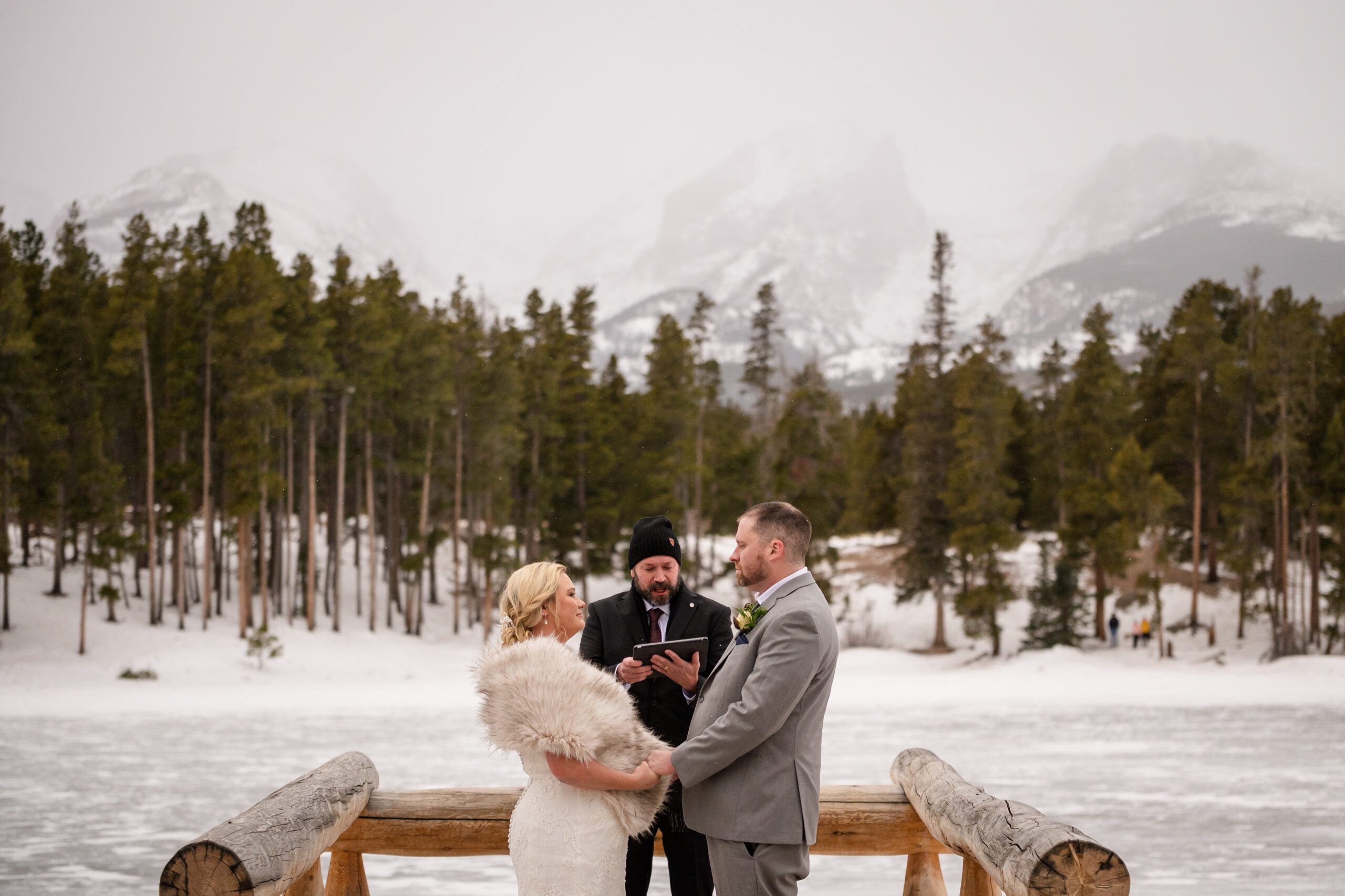 the bride and groom looking sweetly at each other during their Winter Elopement ceremony at Sprague Lake.  