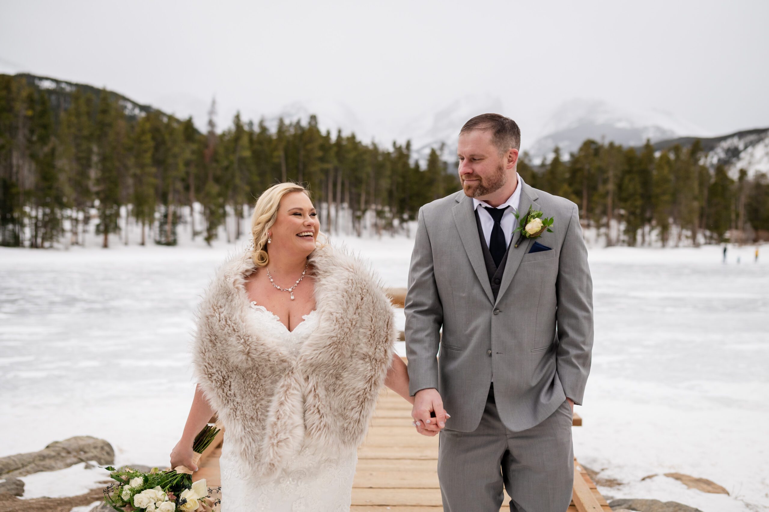 The bride and groom hold hands on the frozen lake after their Winter Elopement at Sprague Lake. 