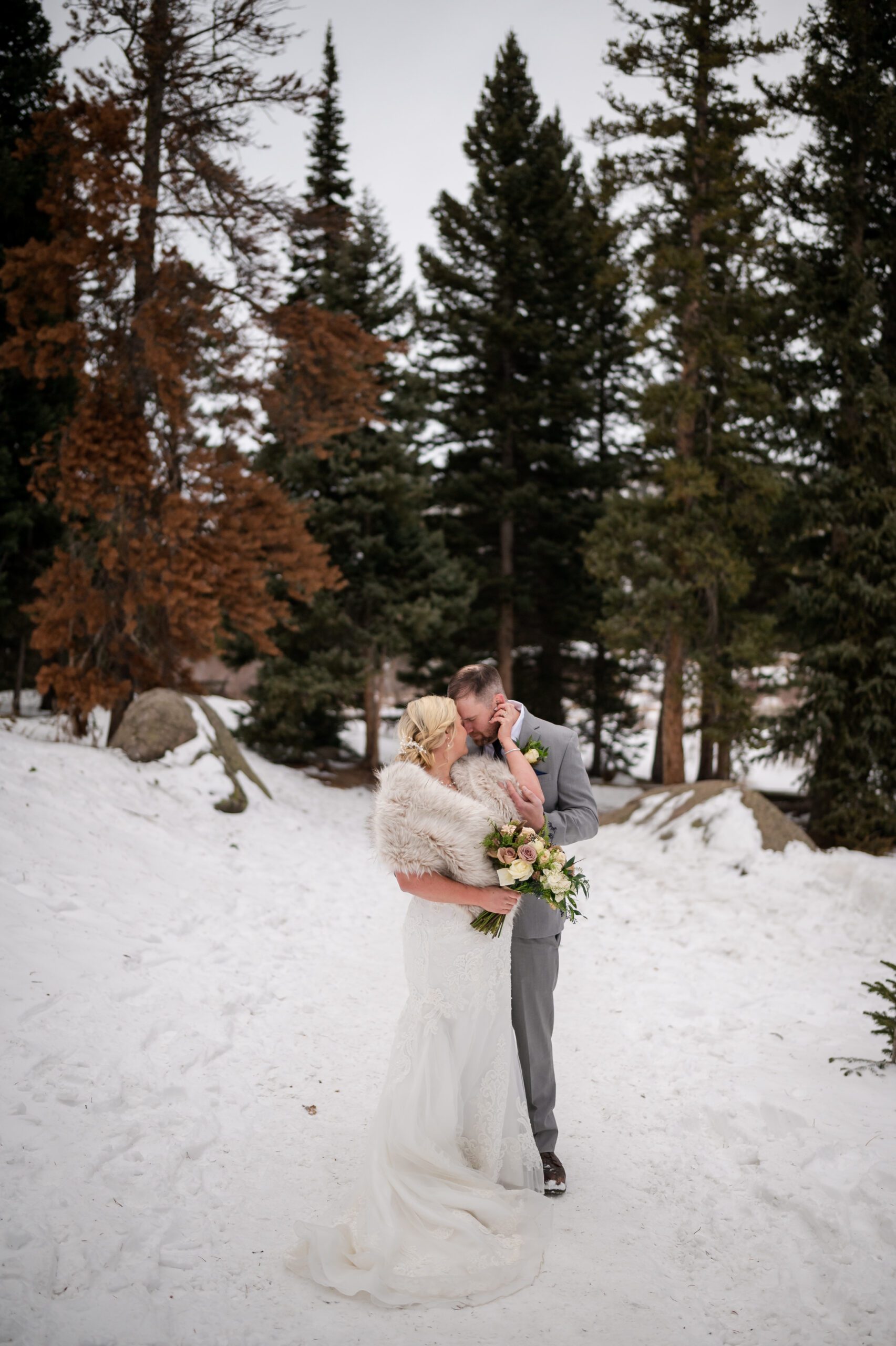 the bride and groom cuddle up closely during thier Winter Elopement at Sprague Lake. 