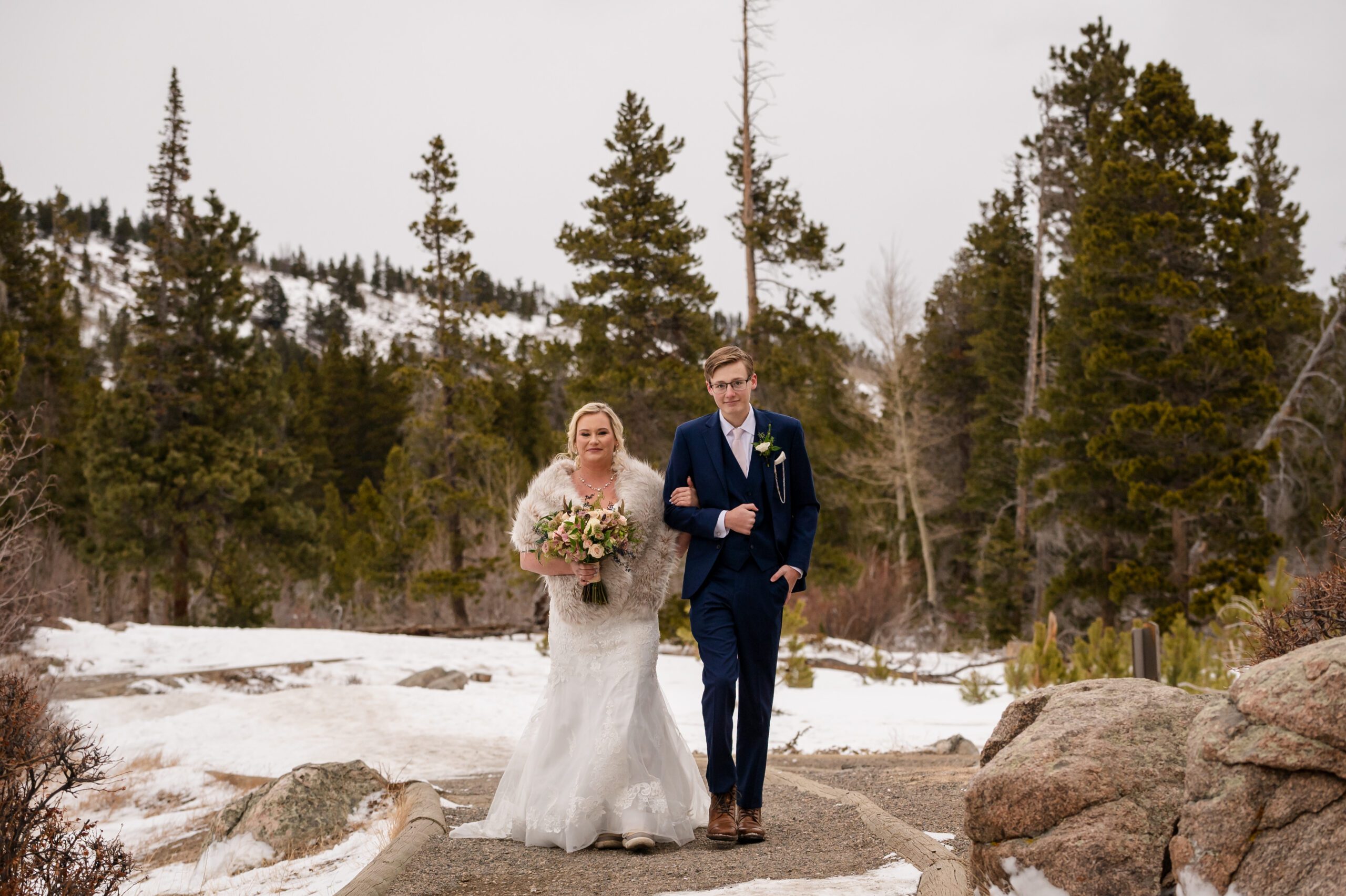 Bride walking down the aisle with her son during her Winter Elopement at Sprague Lake. 