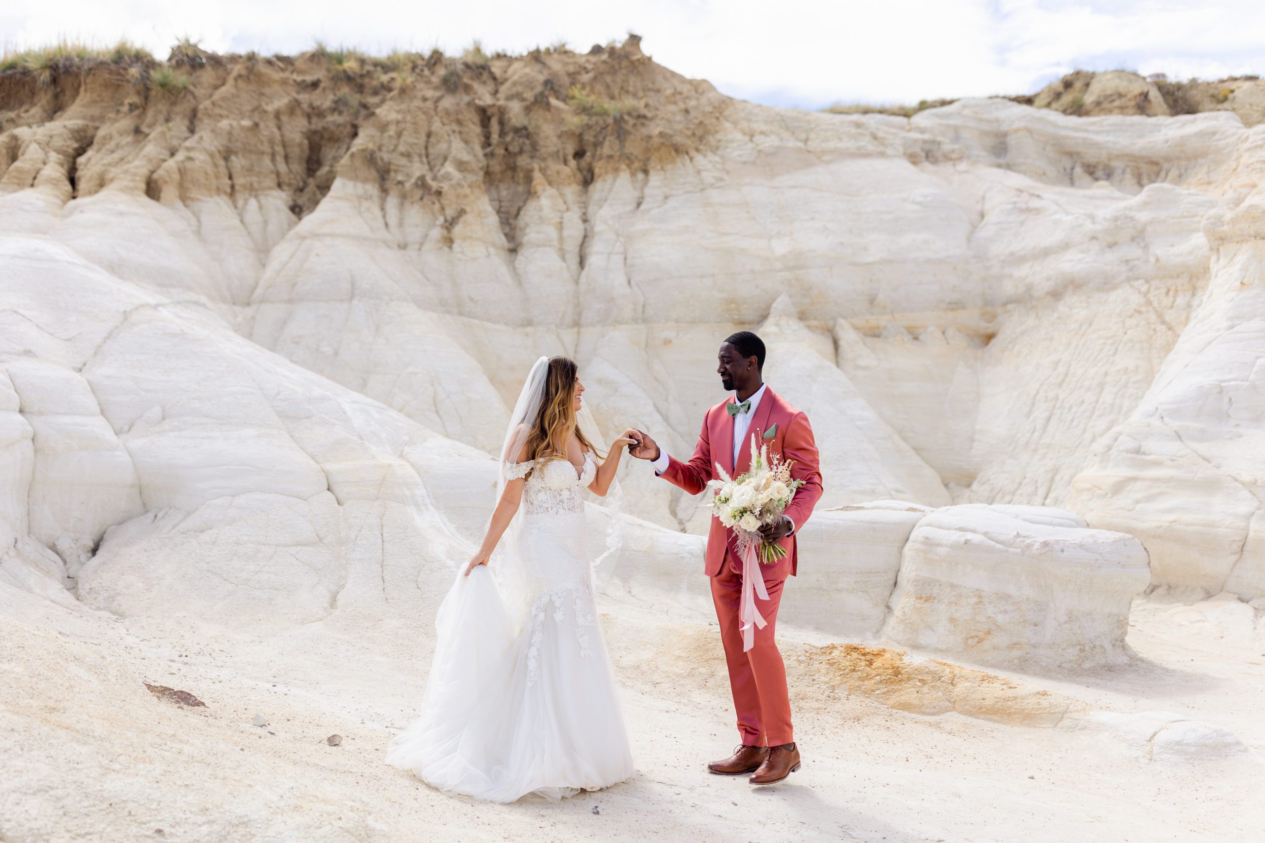 Bride and groom hold hands at the Paint Mines before their elopement at the Garden of the Gods