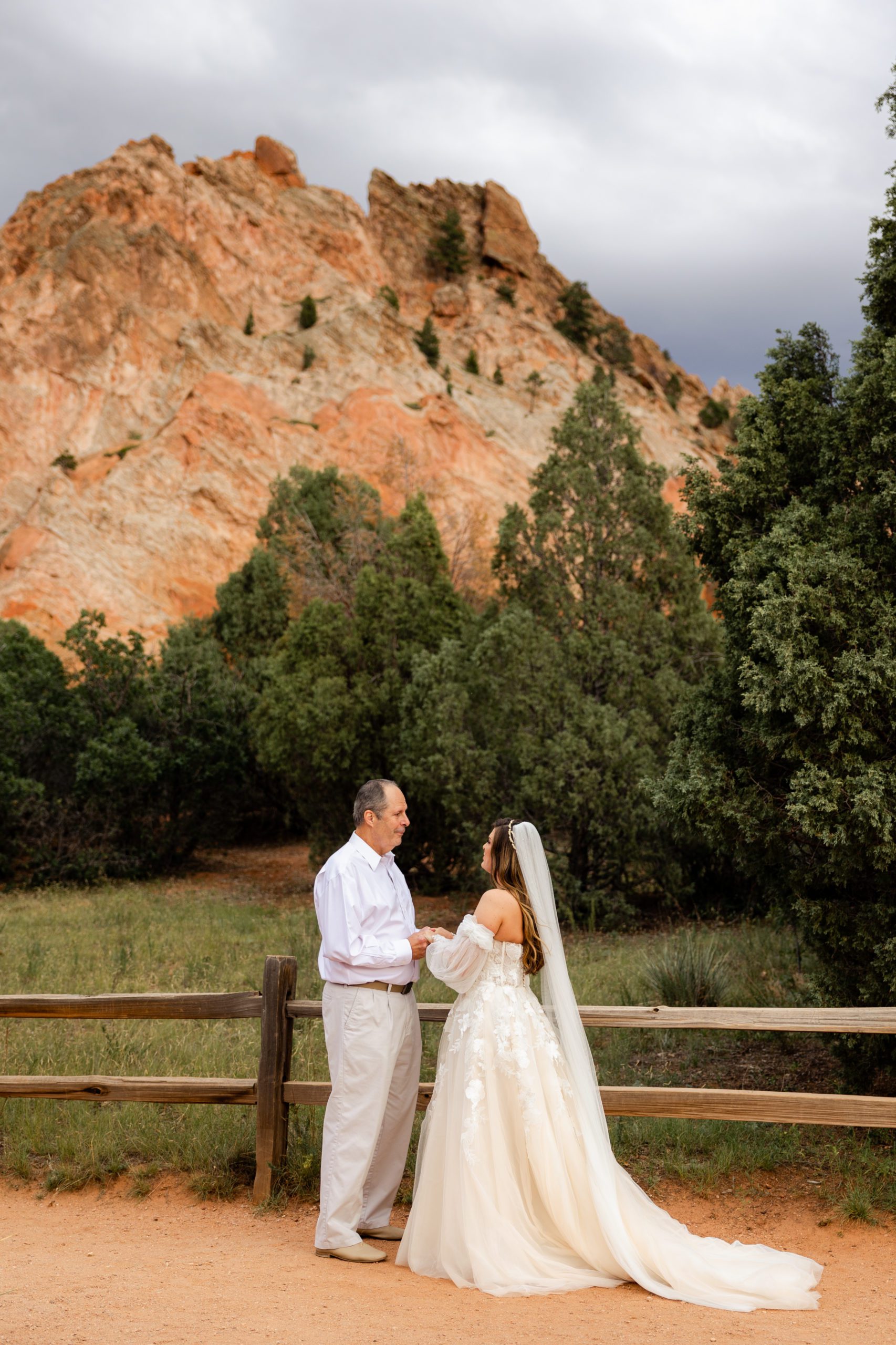 Father and daughter hold hands before the bride's elopement at the Garden of the Gods