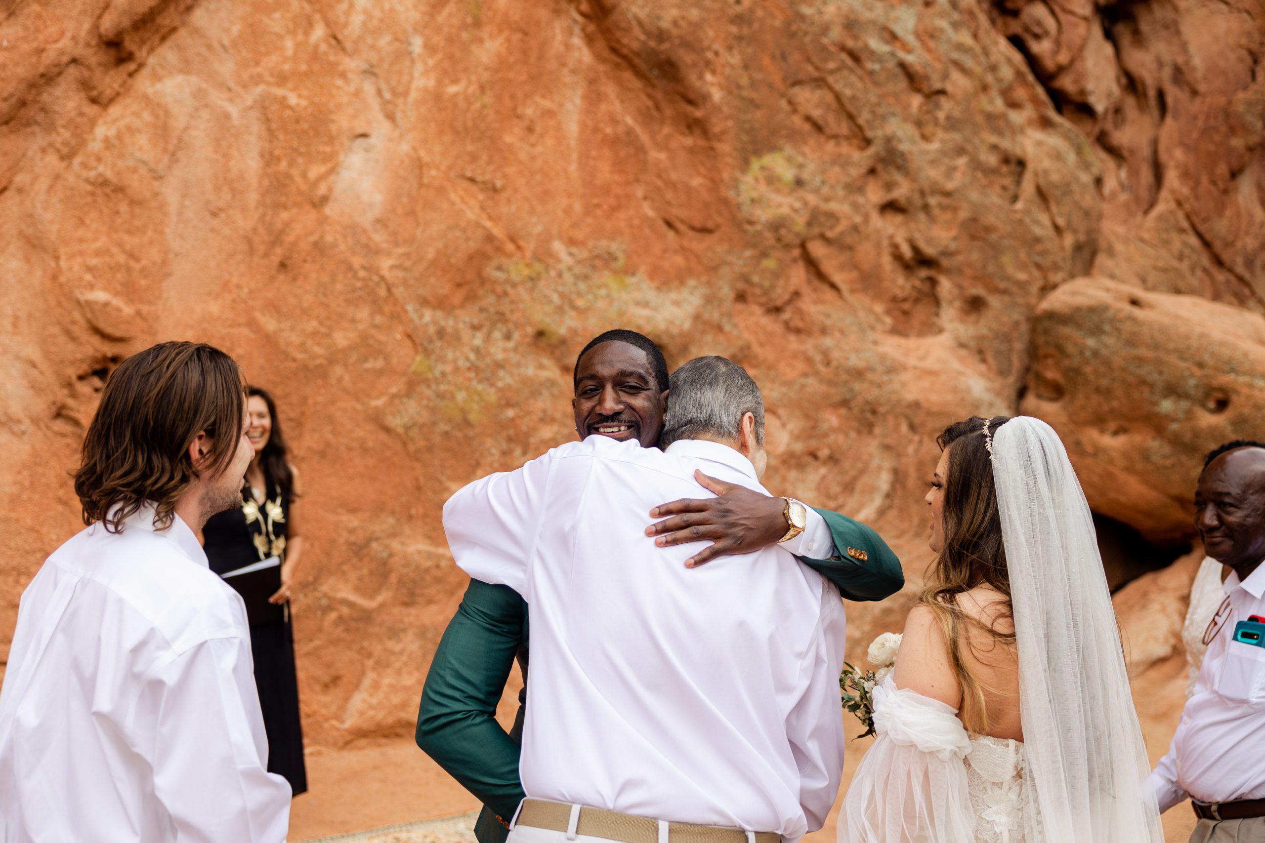 Groom hugs the father of the bride before their ceremony at the Garden of the Gods