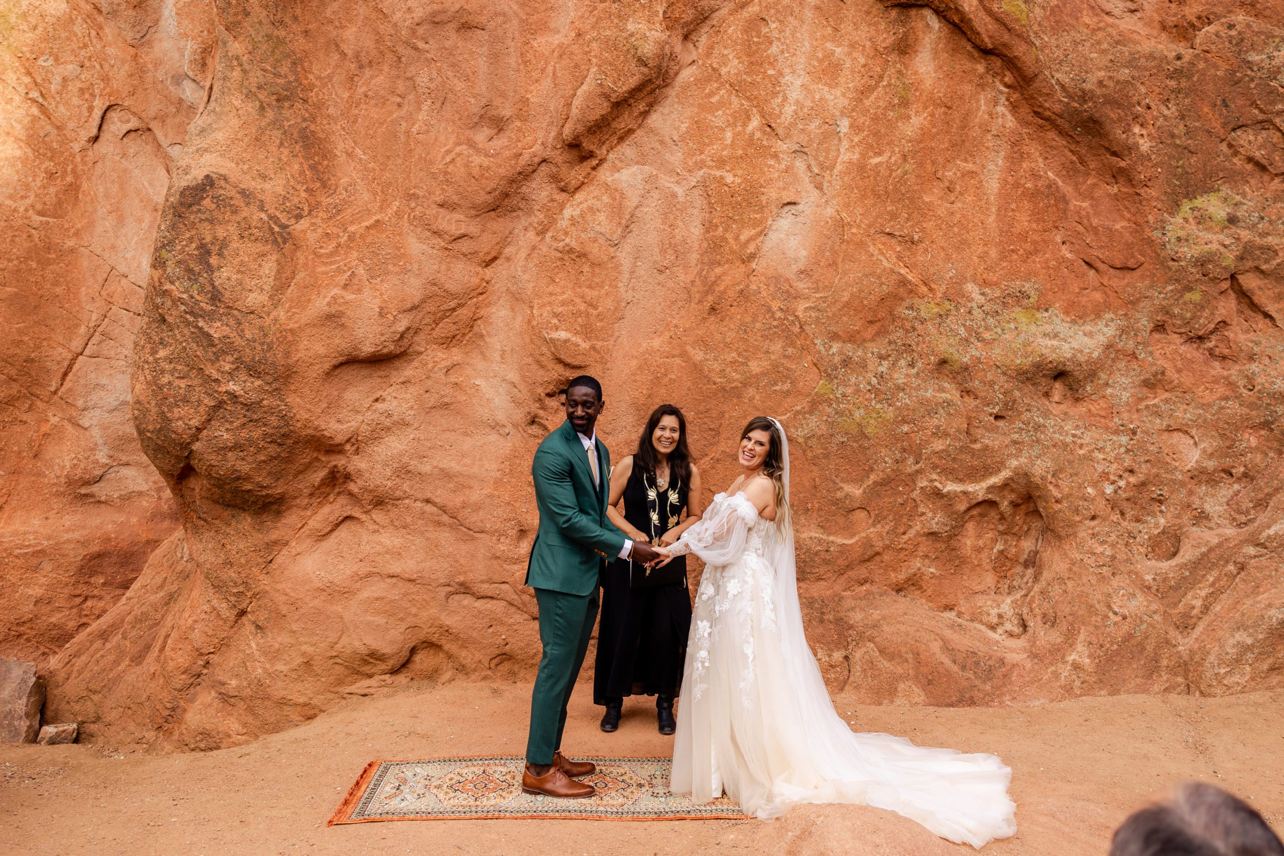 bride and groom during the ceremony, smiling at their guest during their elopement at the Garden of the Gods