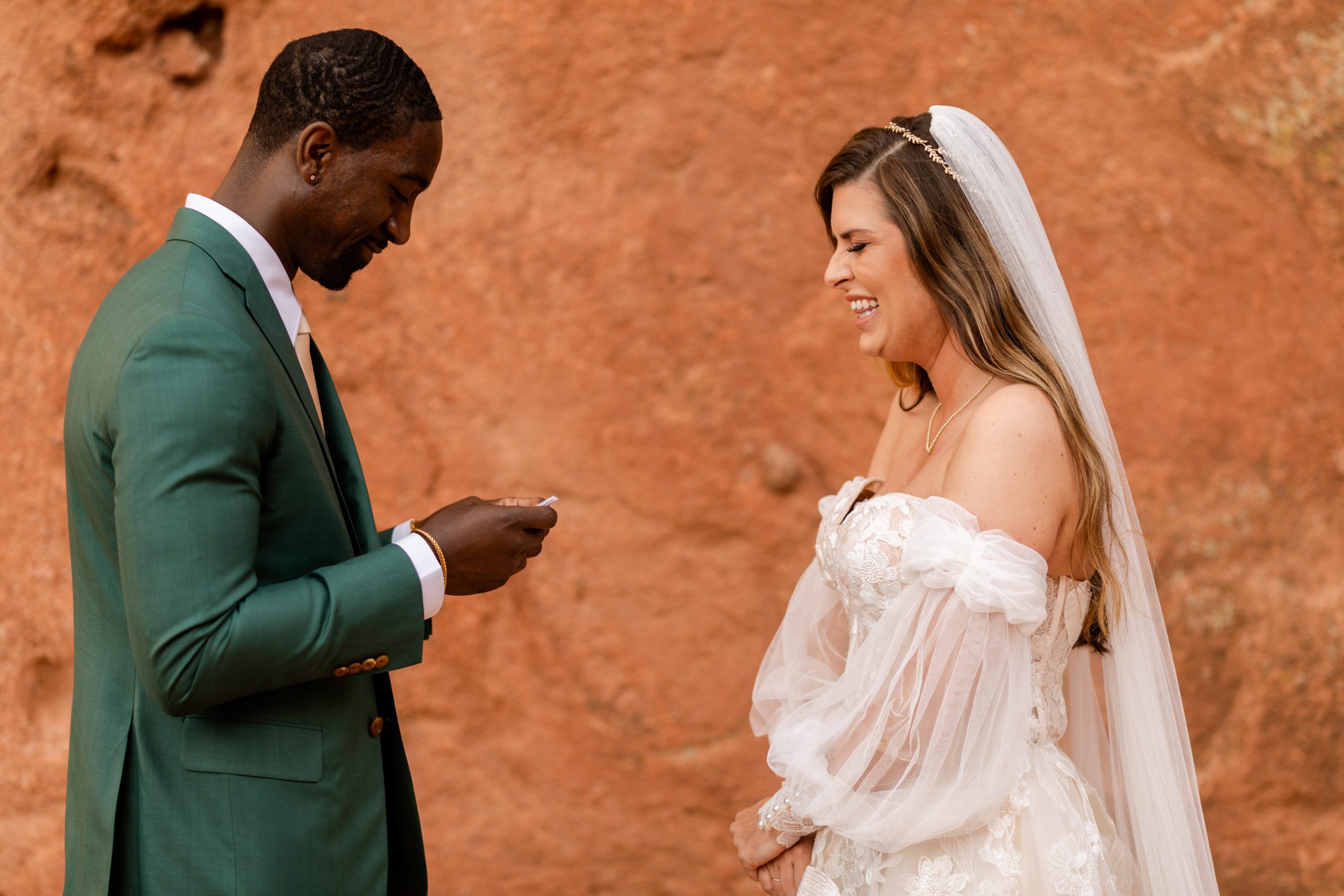 Bride laughing as groom reads his vows during their elopement at the Garden of the Gods