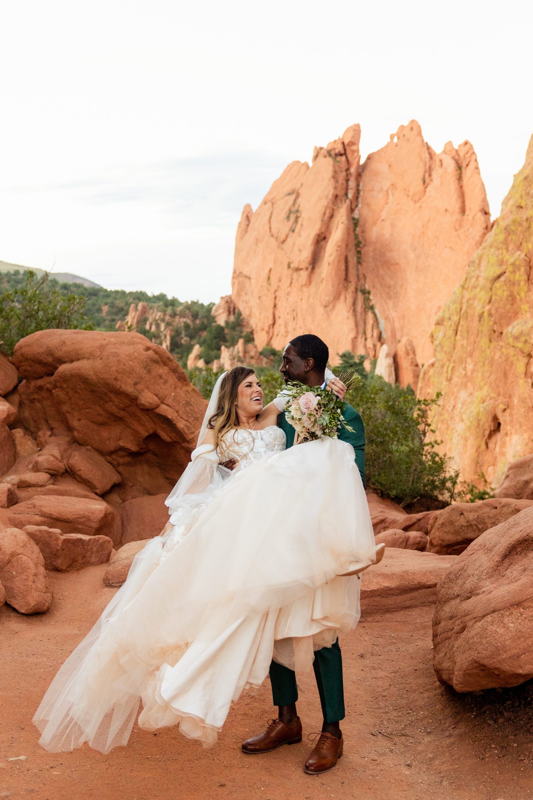 Groom carries his bride after their elopement ceremony at the Garden of the Gods. 