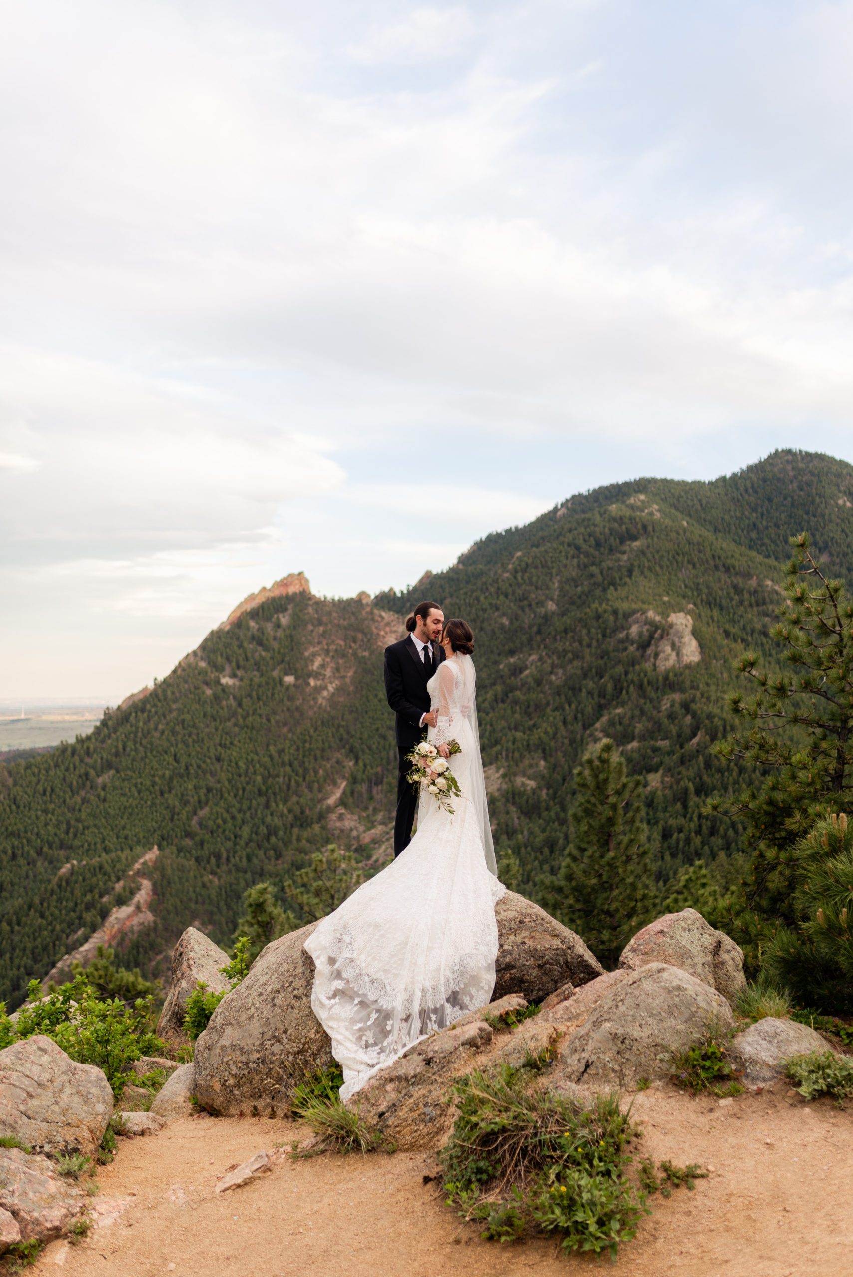 Photo of bride and groom on a rock near Sunrise Amphitheater. 