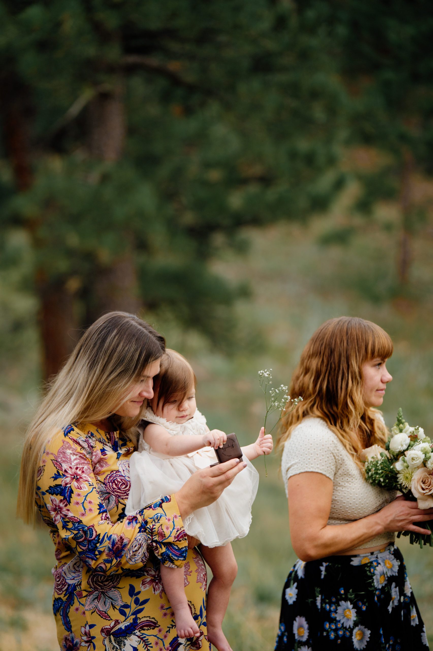 The bride and grooms daughter warms the rings during their artist point elopement 